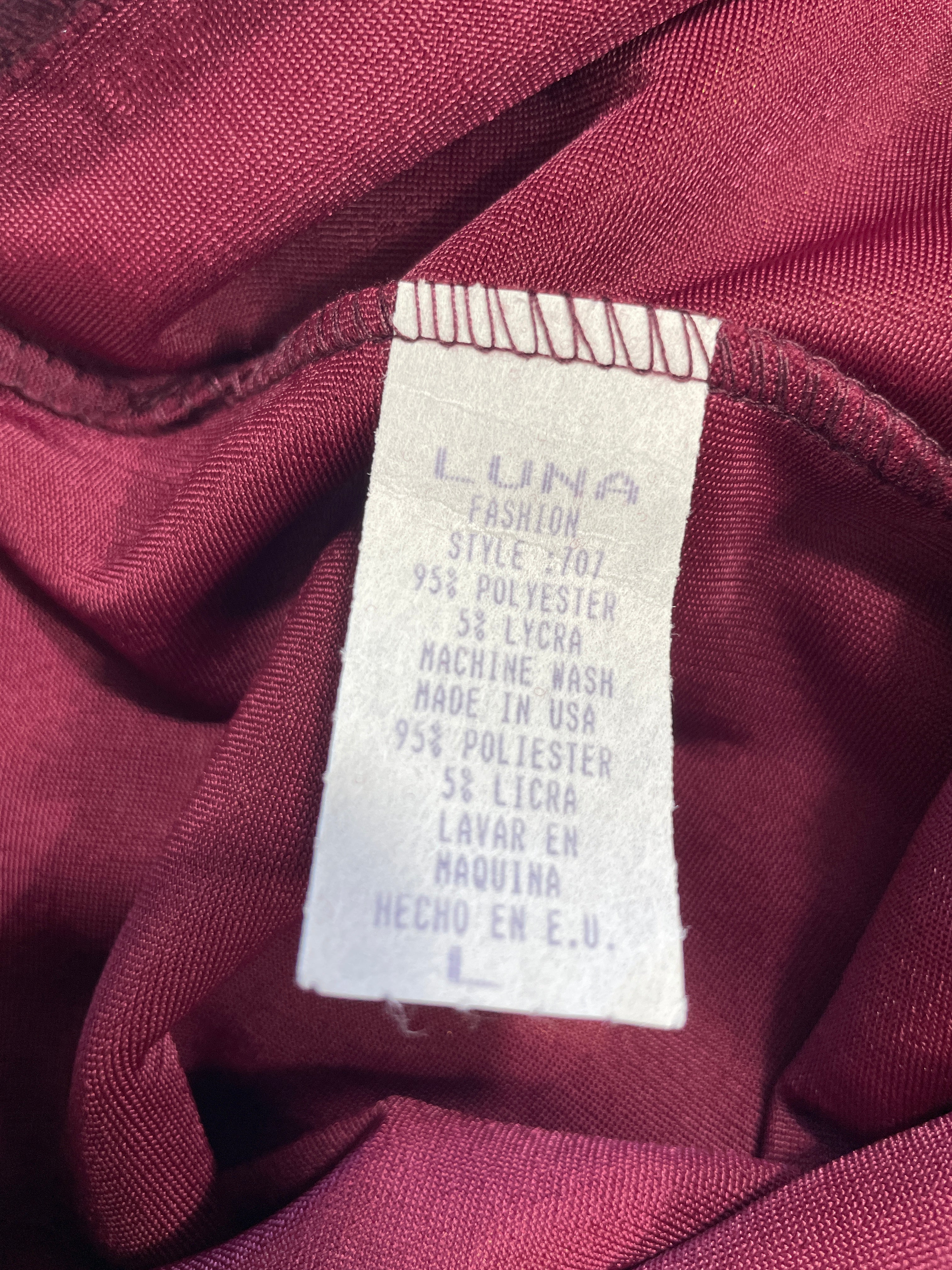 Close-up of a garment's interior neck label reading 'LUNA FASHION' with fabric details, set against a dark burgundy satin-like lining.