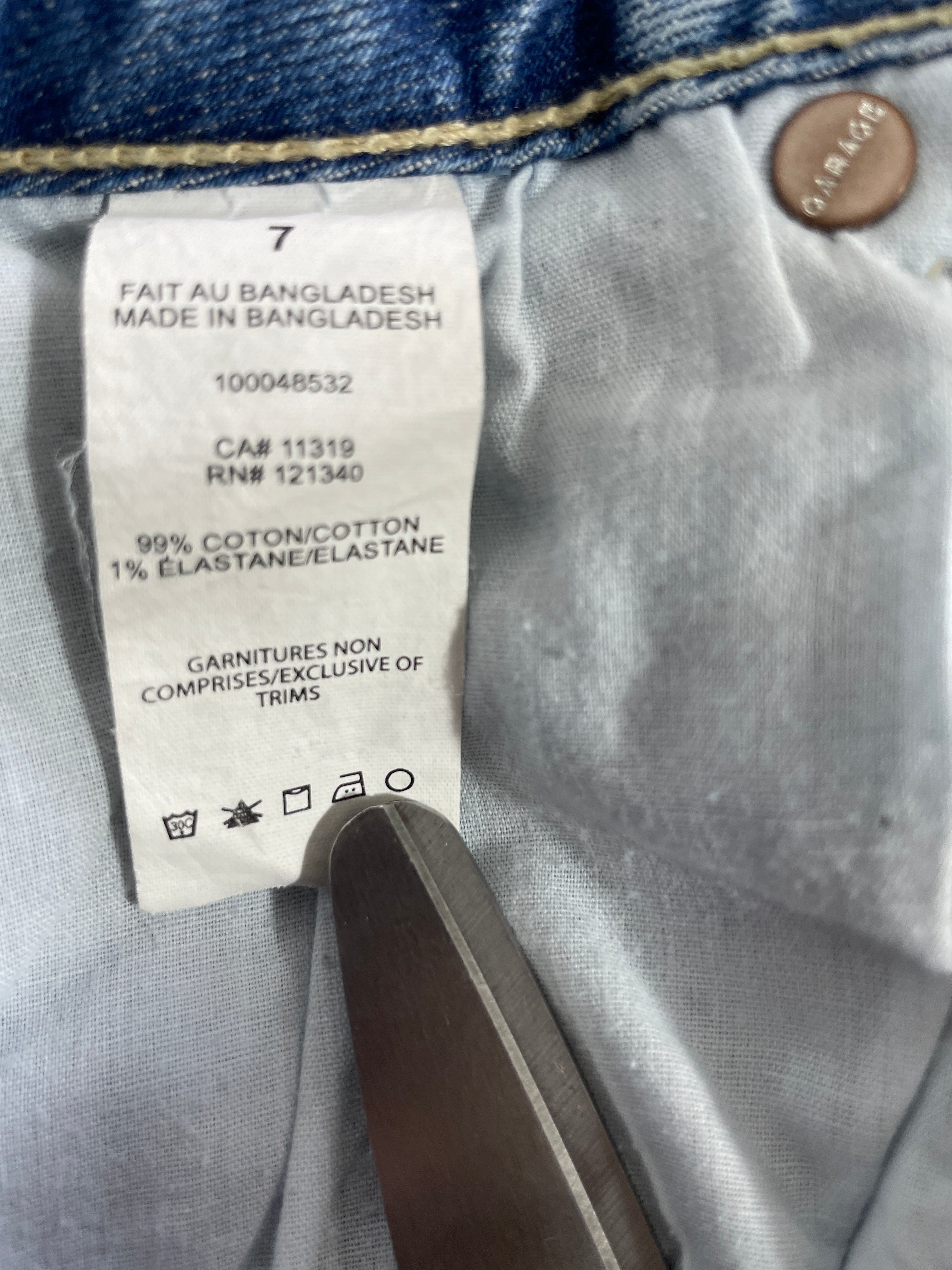 1. Size 7 Garage light wash blue jeans 99 percent cotton fabric care label made in Bangladesh