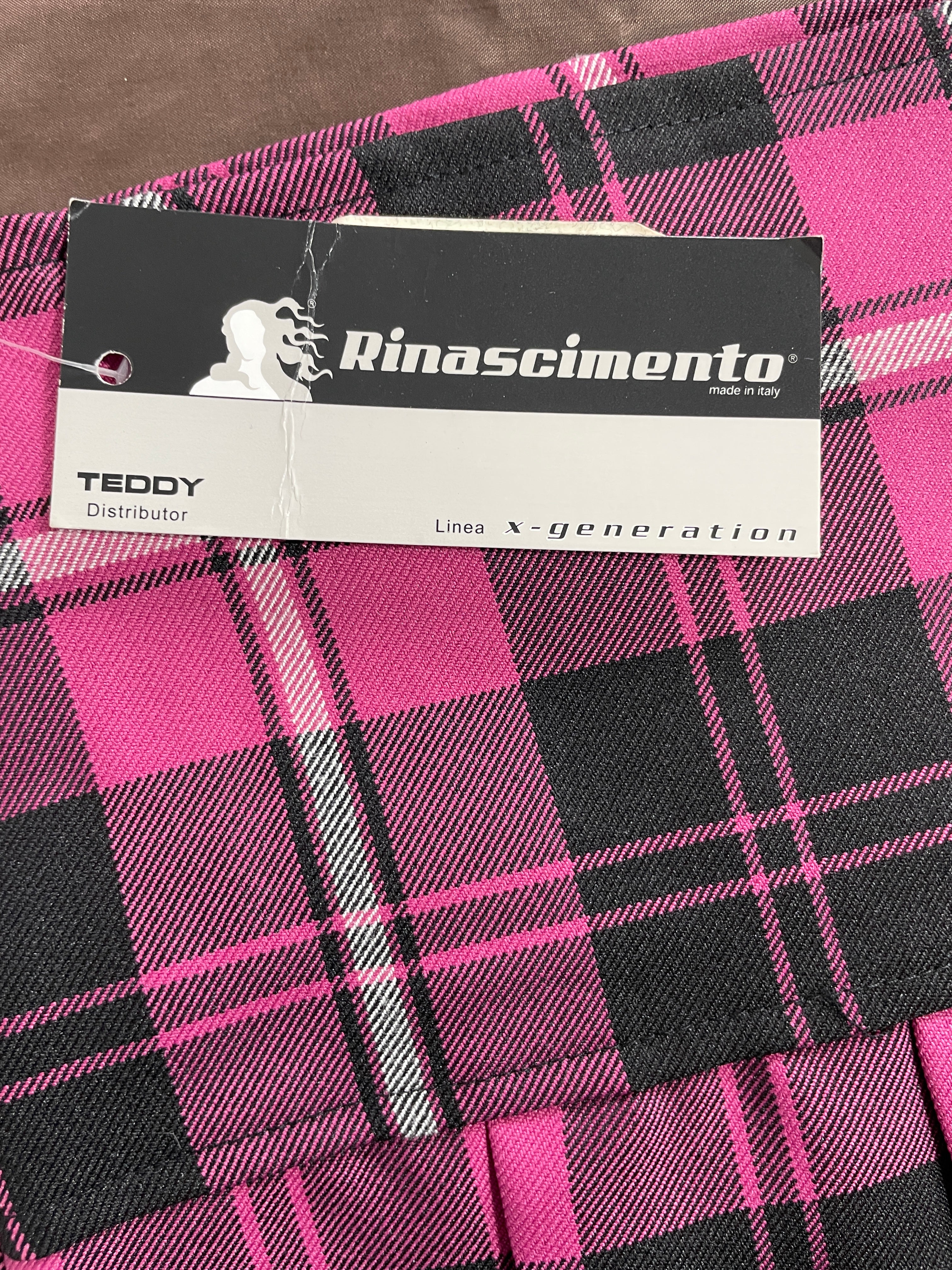 A close-up of a pink and black plaid garment with a visible Rinascento hangtag reading 'TEDDY Distributor' and 'Lines X-generation'.