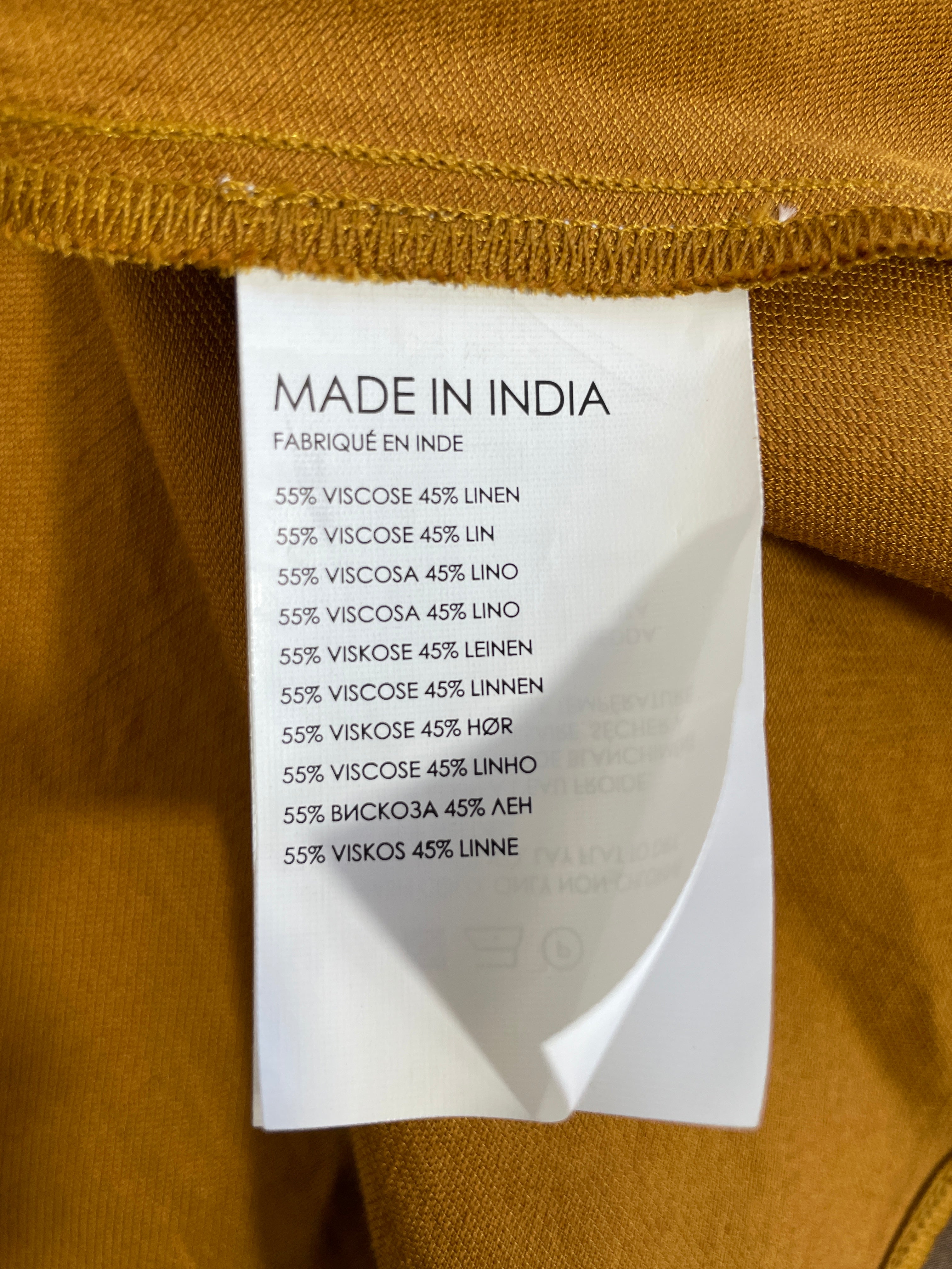 Club Monaco gold midi skirt fabric care label showing 55% viscose and 45% linen