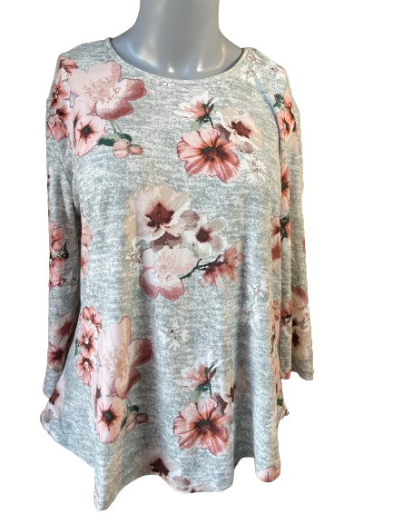 A long sleeve top with a floral pattern in pink and white colors on a grey background, displayed on a mannequin.