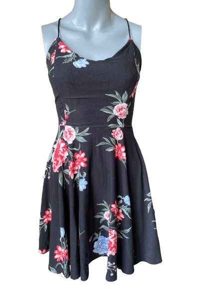 A black floral summer dress displayed on a mannequin, featuring a V-neckline and short sleeves with a flared skirt.