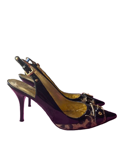 A single black Guess slingback heel with leopard print design and a buckle toe feature, displayed against a colorful background.