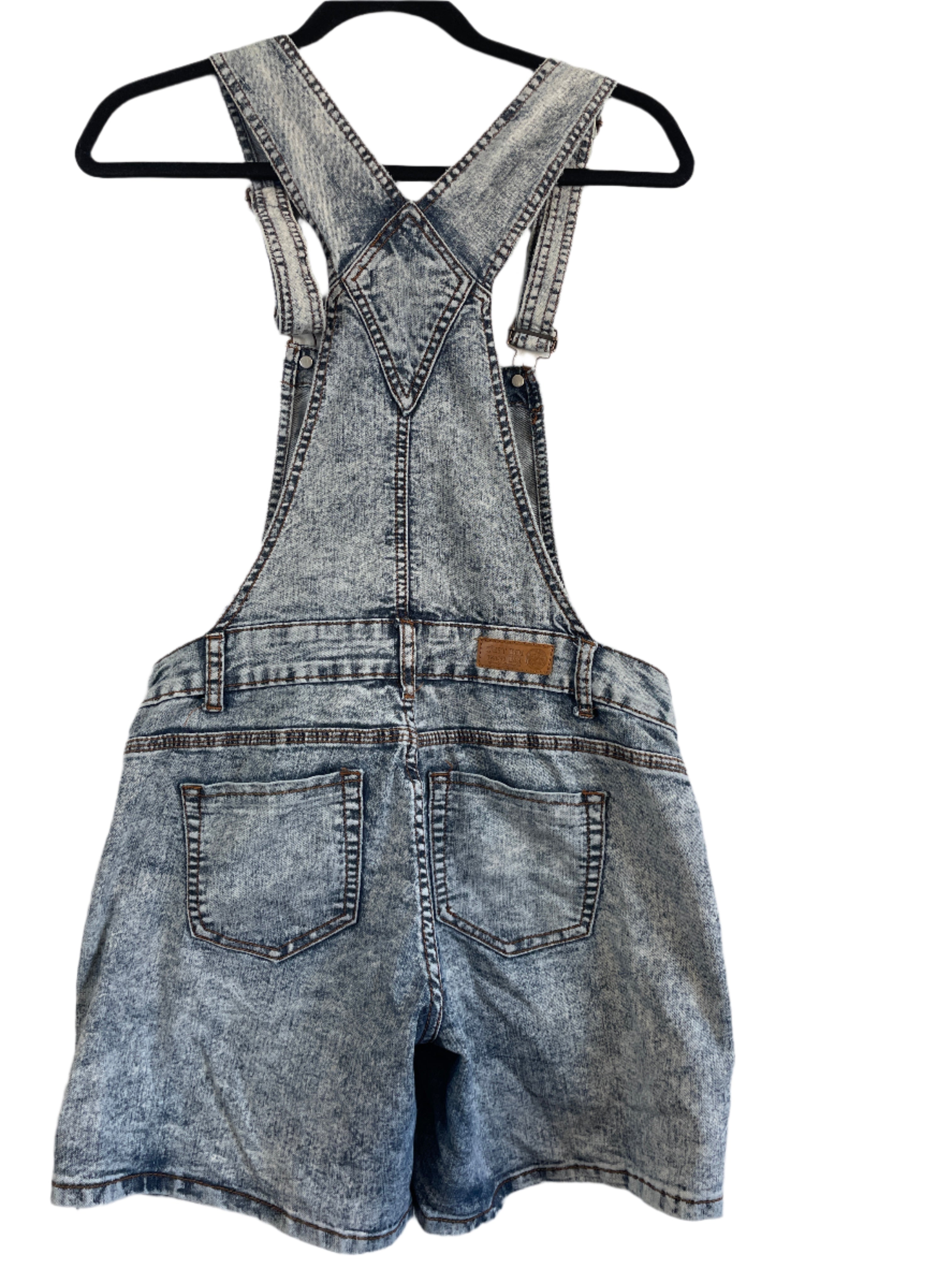 Blue denim overalls against a white background
