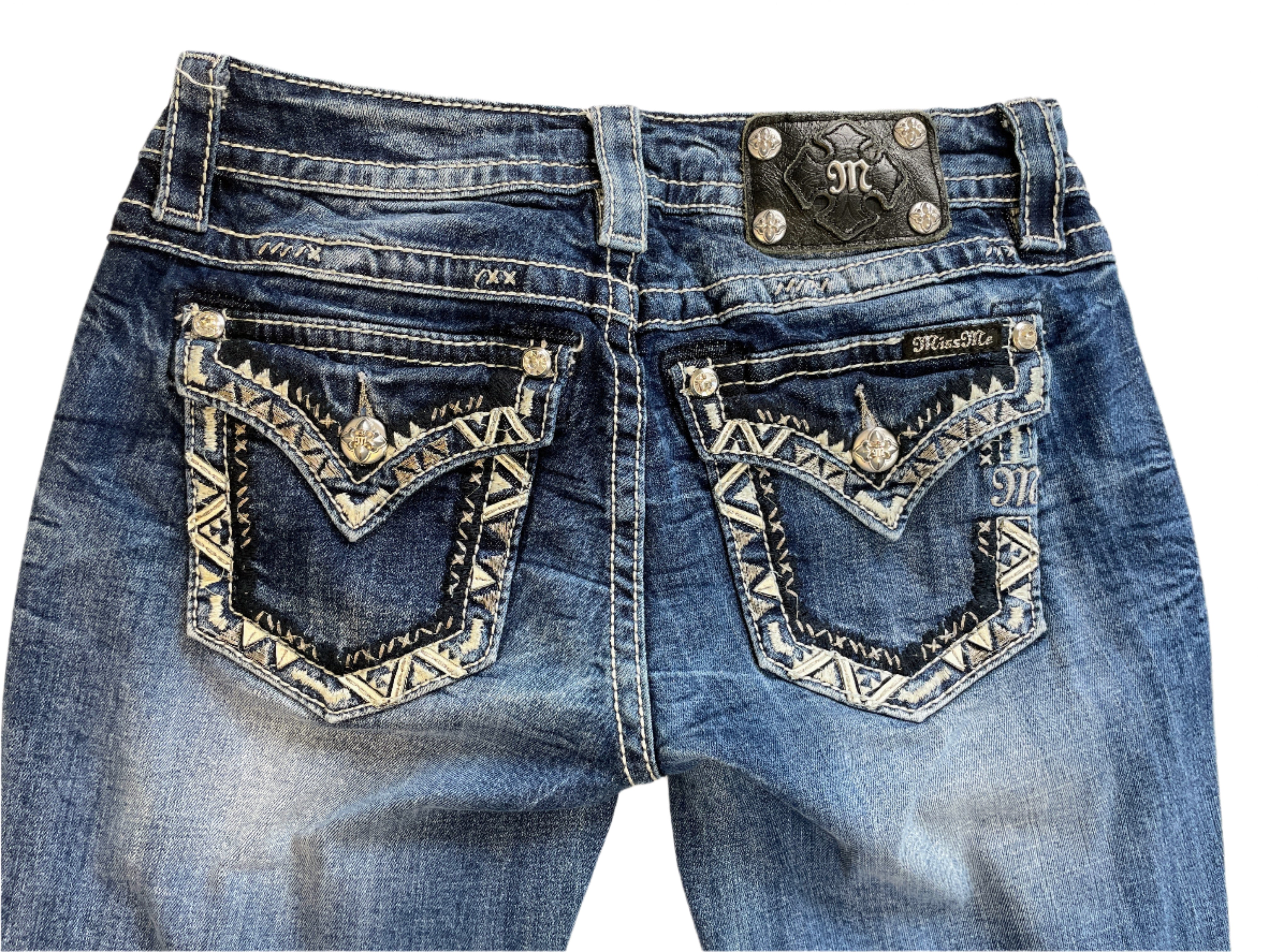 Blue jeans with decorative stitching on the back pockets, displayed on a white surface.