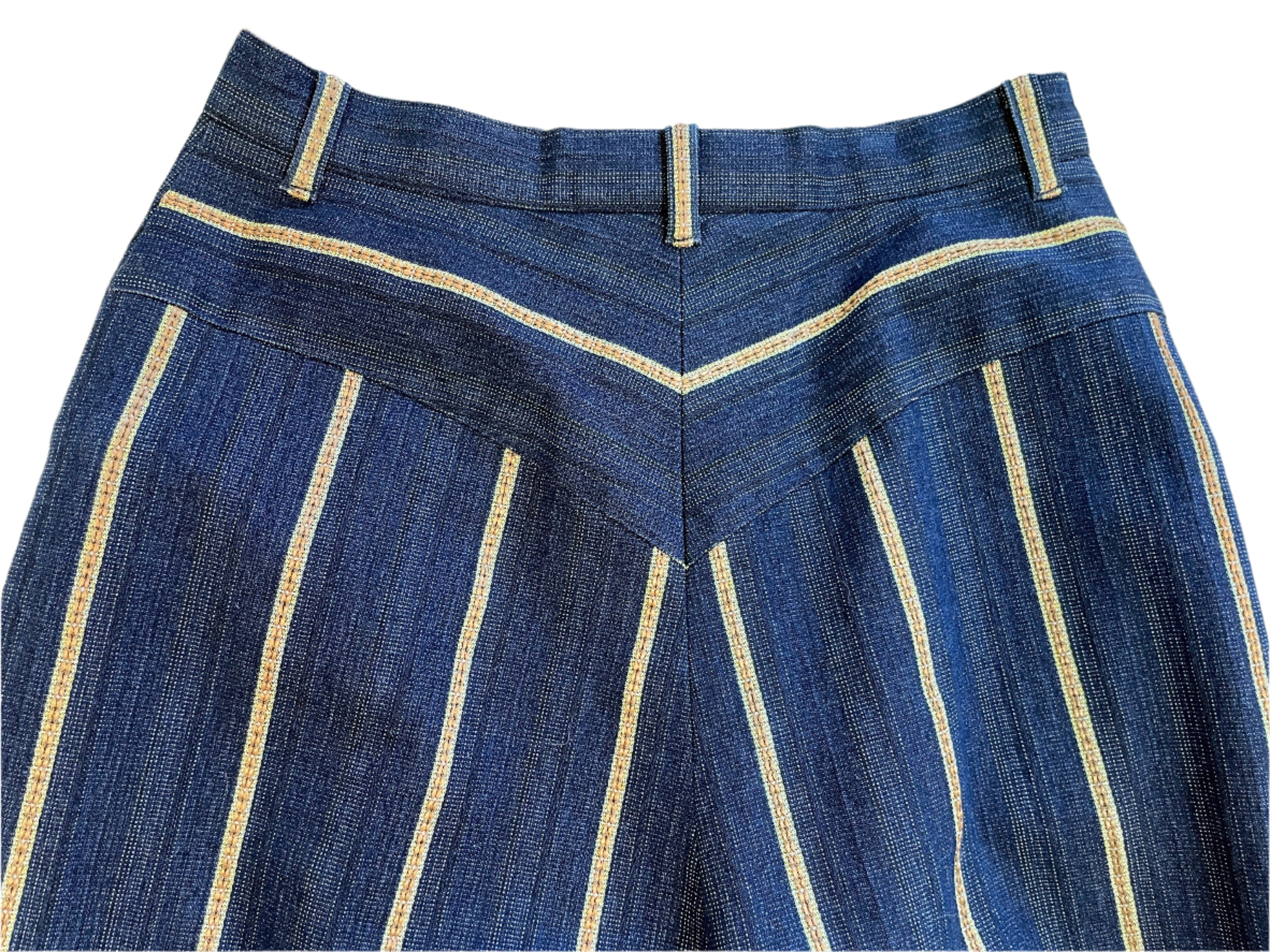 Blue denim pants with gold  stitching on a white surface