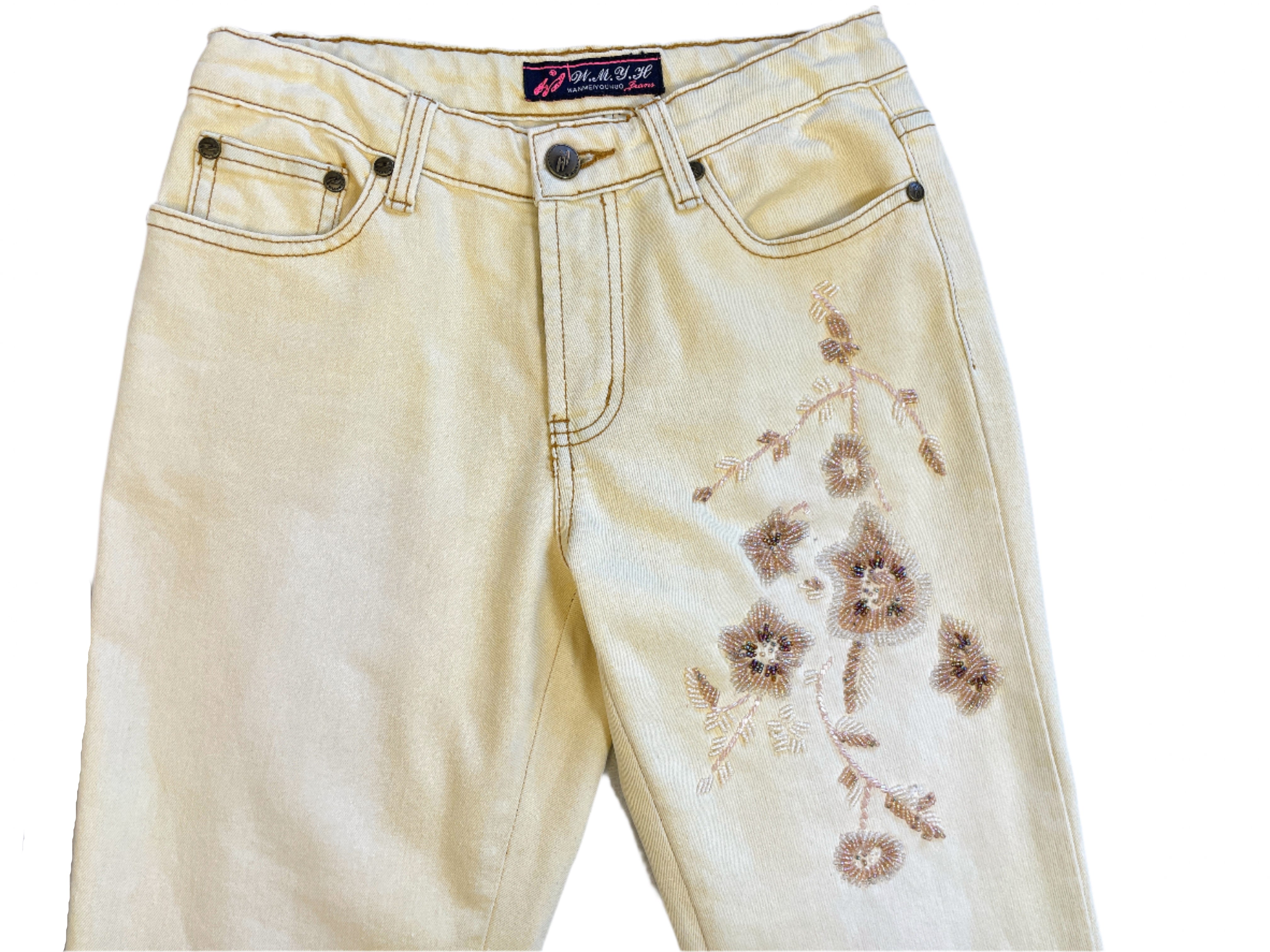 Beige jeans with floral embroidery on a light blue surface