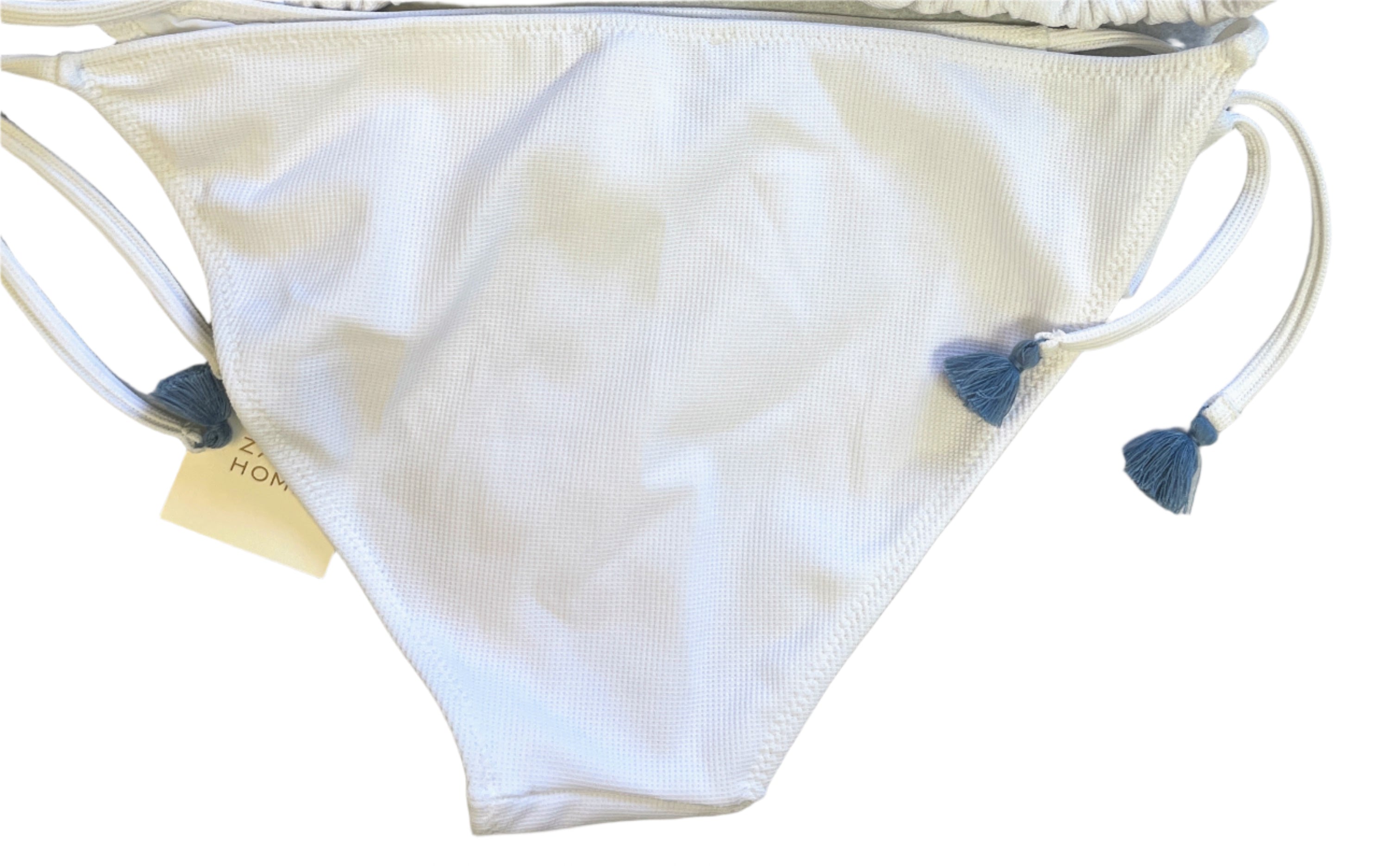 White bikini bottoms with blue accents on a light gray surface