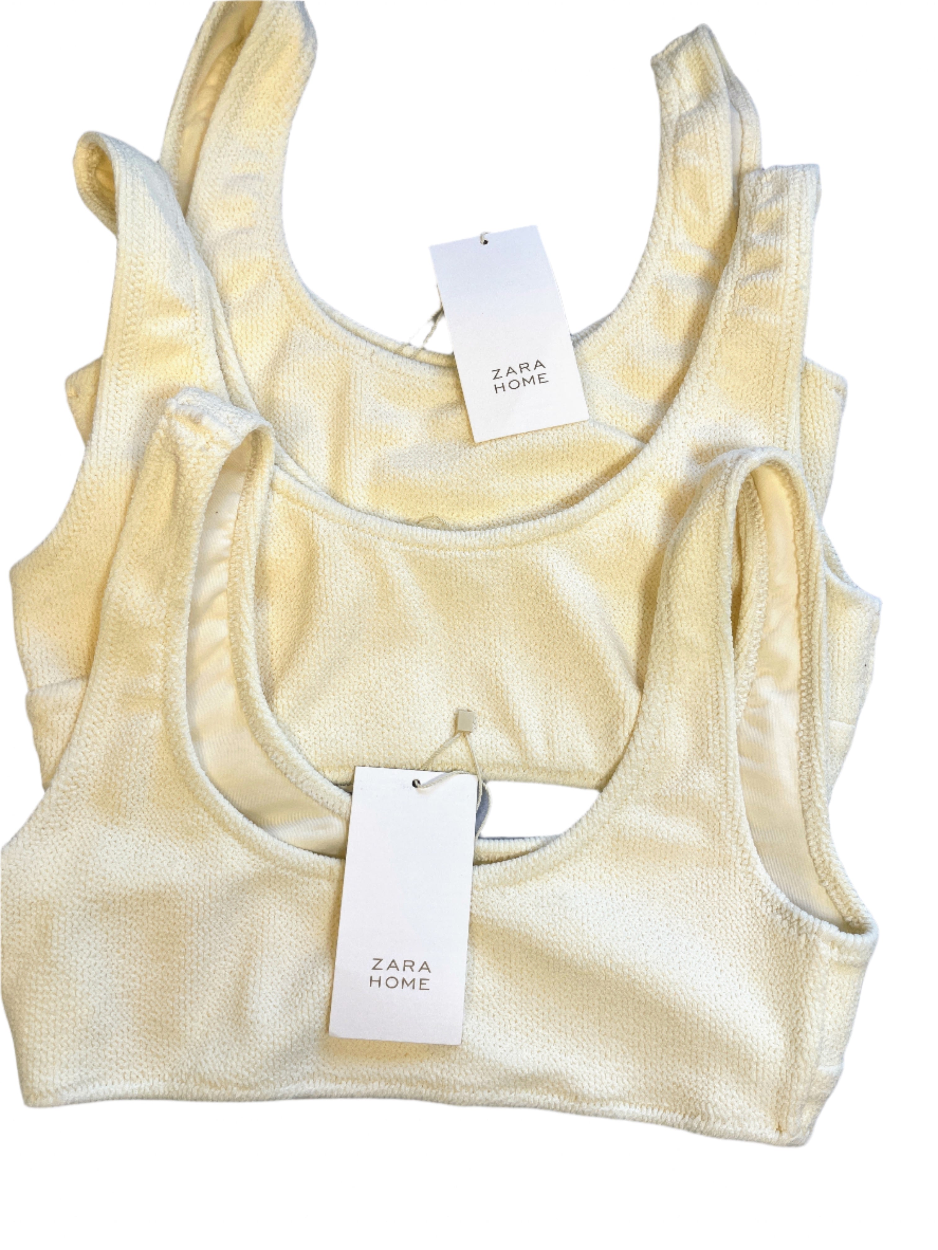 Yellow tank top with 'Zara Home' tag on a light blue surface