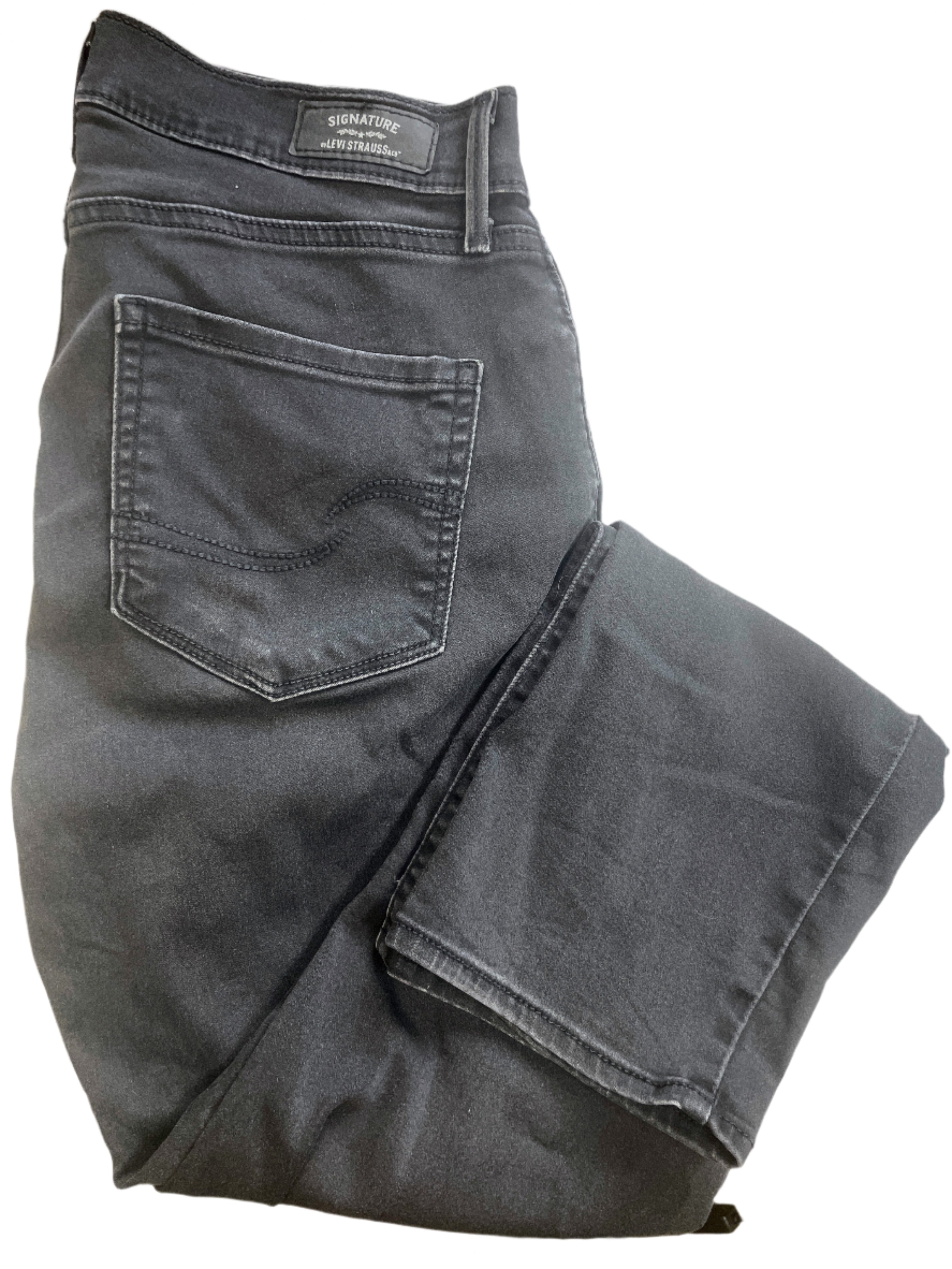 Folded pair of black jeans on a white surface