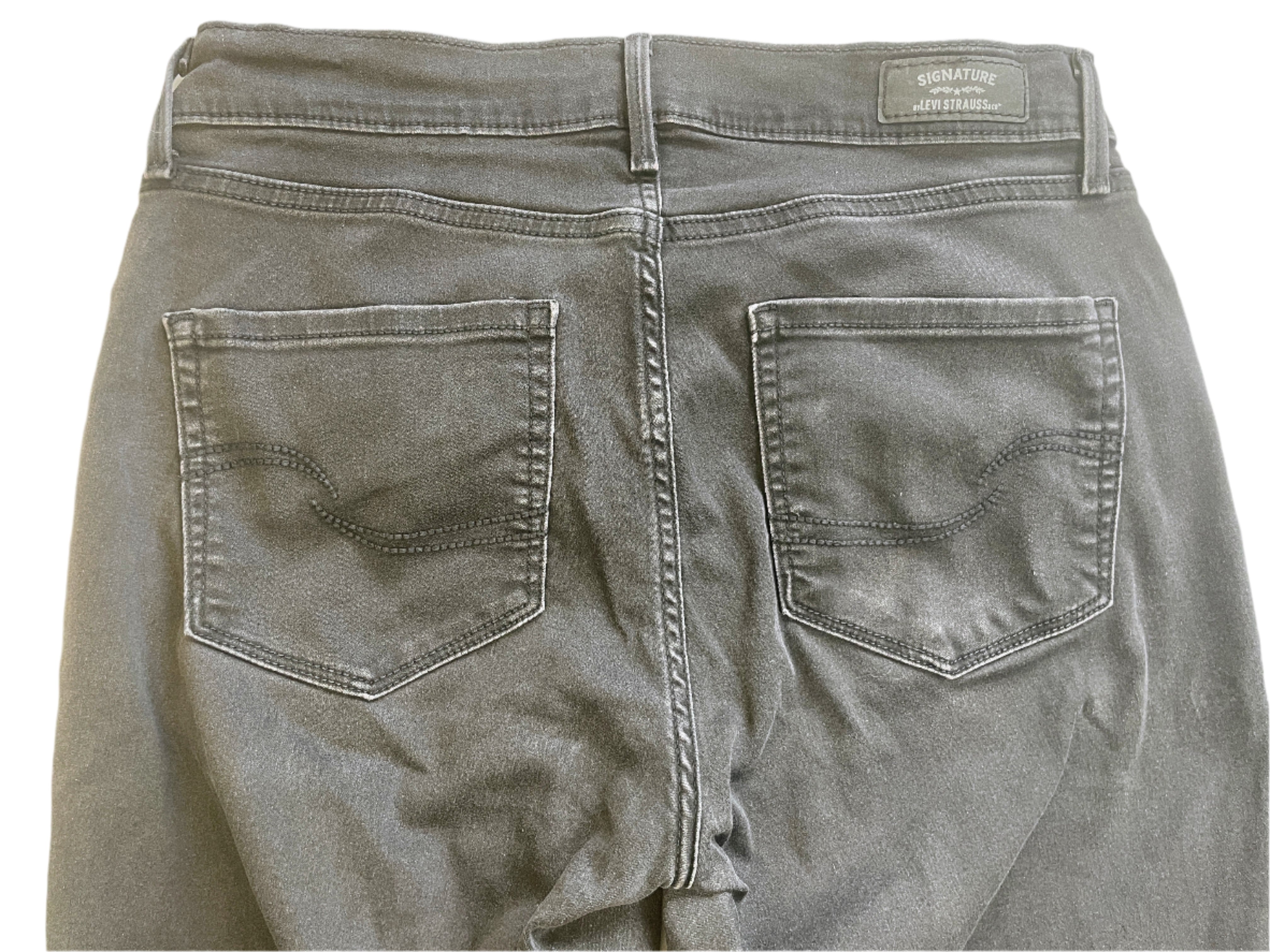 Back view of black jeans with a brand label on a white background