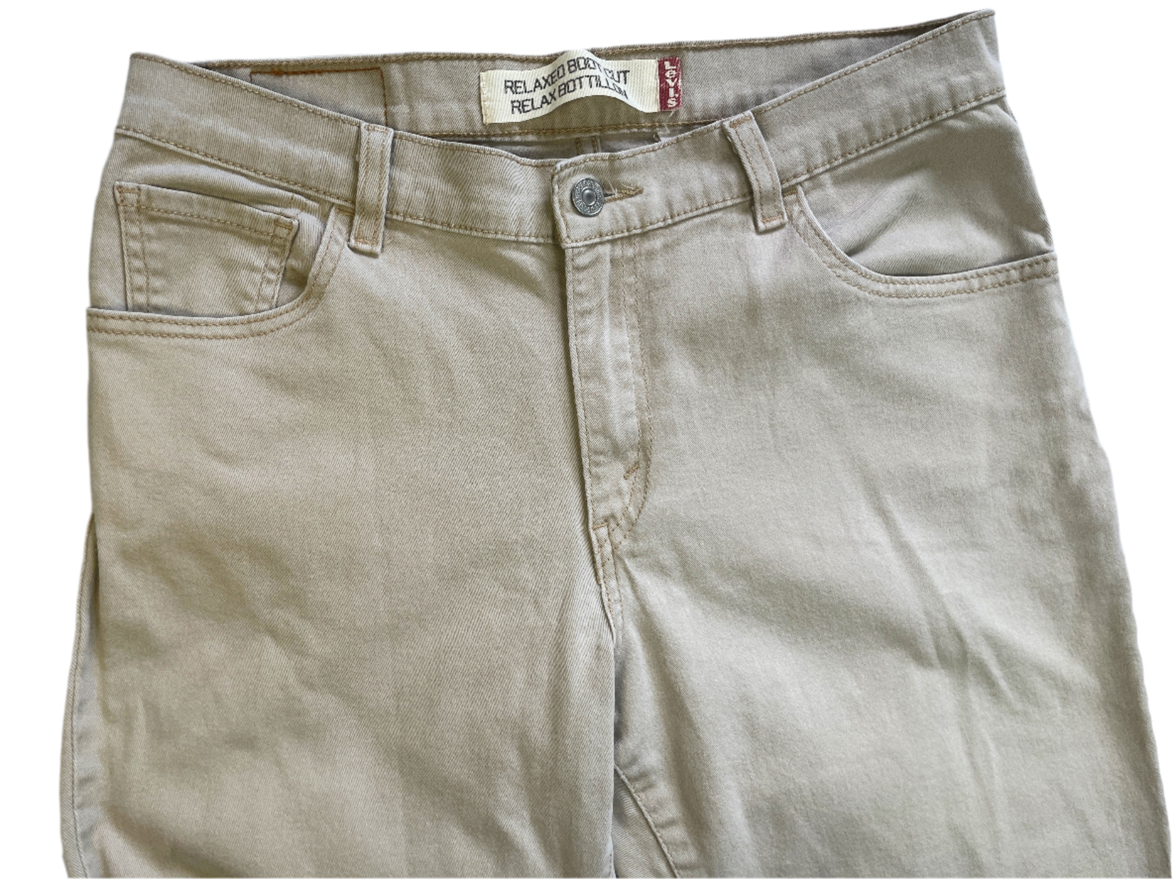 Beige pants with a brand label on a light gray background