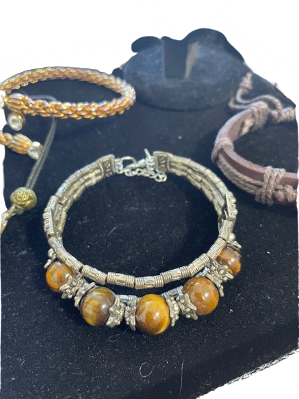 Bracelets with brown beads and wire wrapping on a dark surface