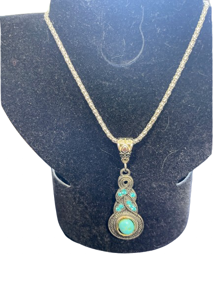 Necklace with a turquoise pendant on a black stand