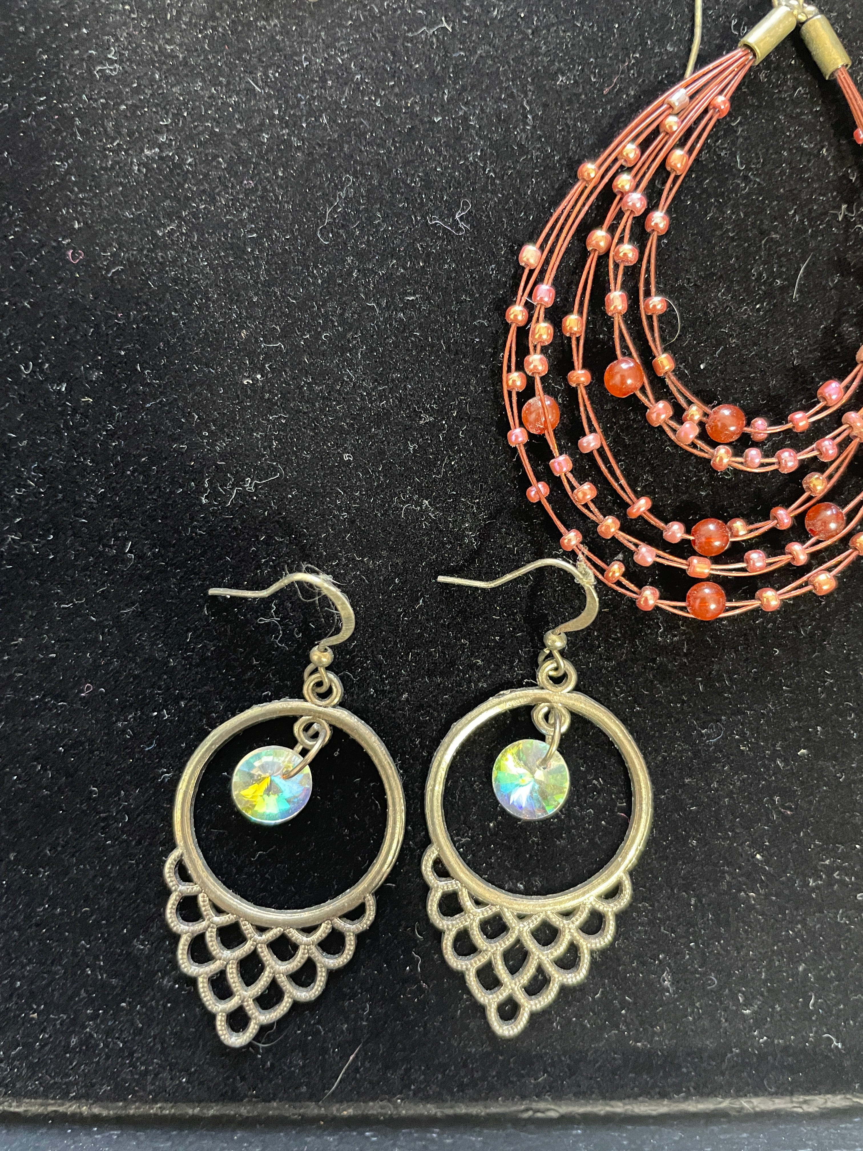 Pair of gold earrings with gemstone drops on a black surface