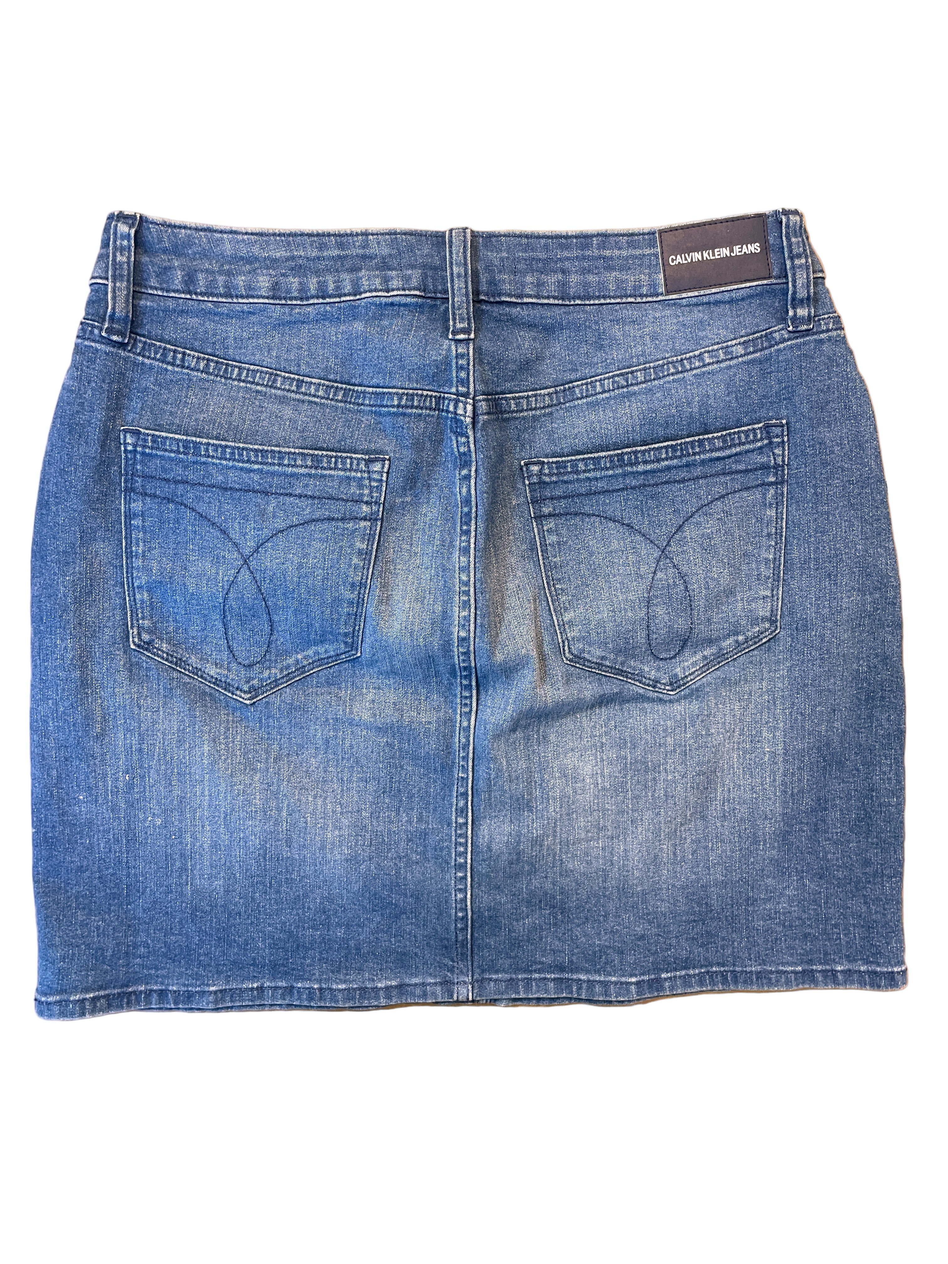 Back view of Calvin Klein medium wash denim skirt with stitched back pockets