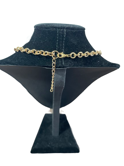Gold chain necklace on a black mannequin bust