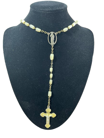 Long crucifix style costume necklace on display bust showing rosary-inspired bead design and cross pendant