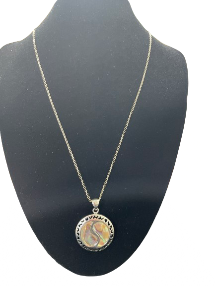 Round abalone style pendant necklace displayed on black bust with silver tone pendant