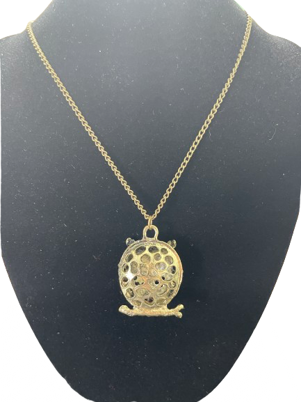 Back view of gold tone owl pendant with openwork design on necklace