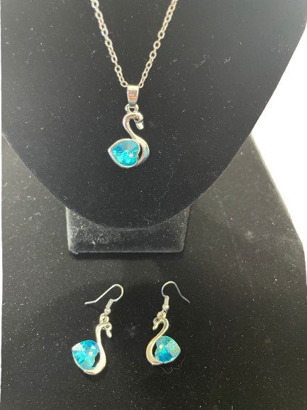 Close up of silver swan pendant with aqua blue crystal heart