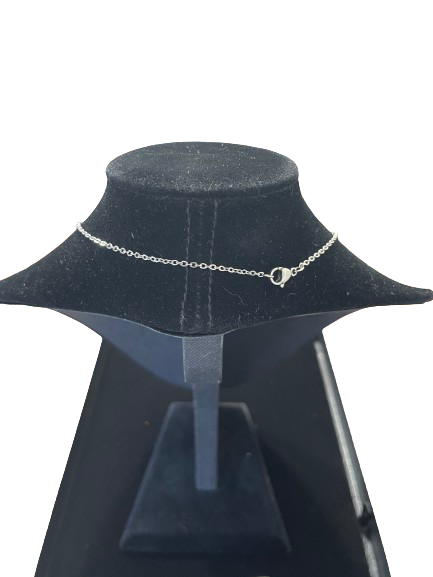 Silver necklace on a black mannequin bust against a white background