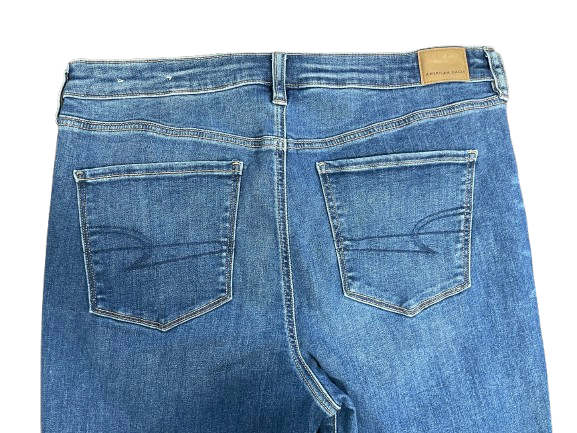 Back view of blue jeans with a brand label on a white background