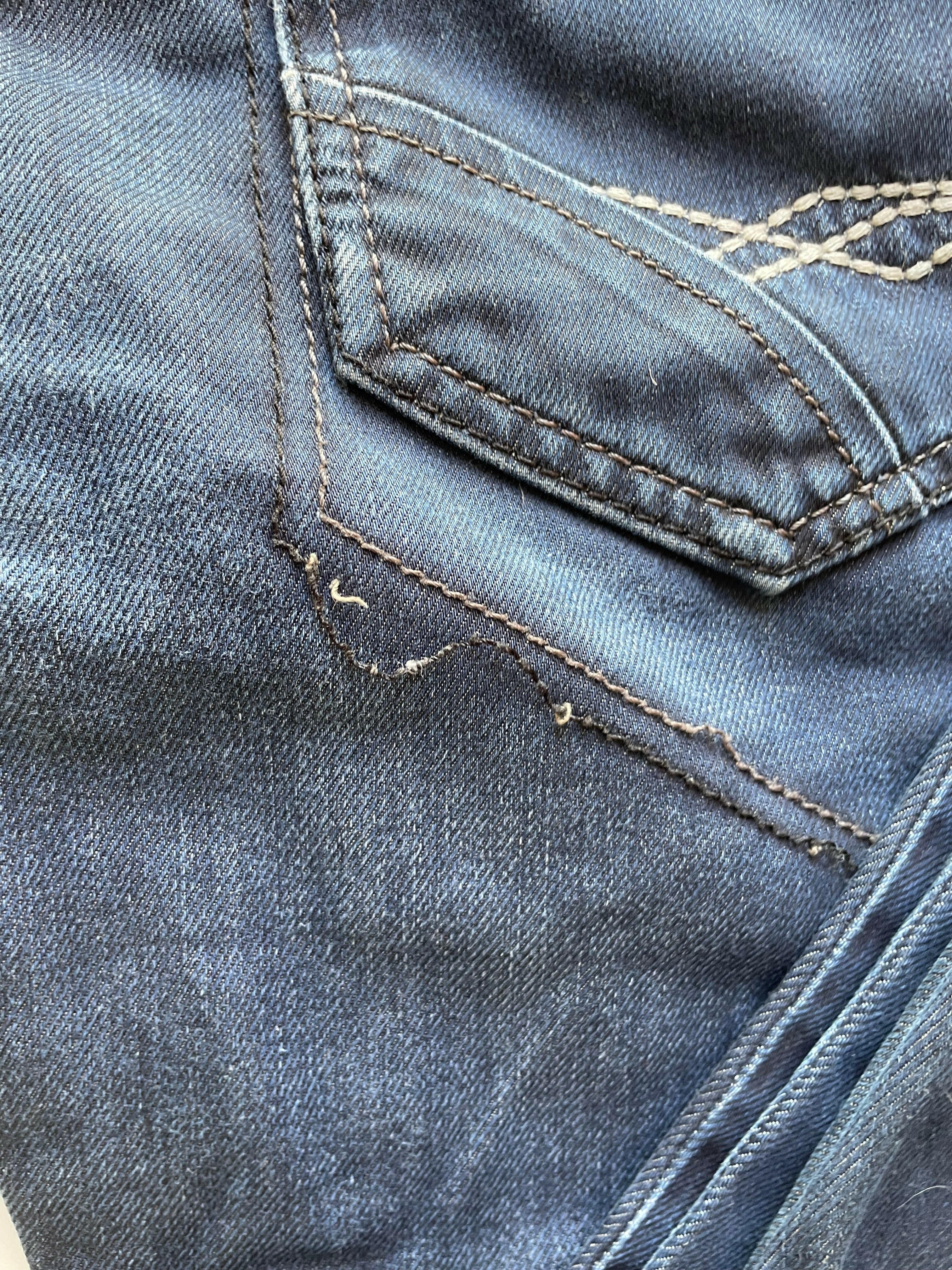 Close-up of blue denim fabric with stitching detail