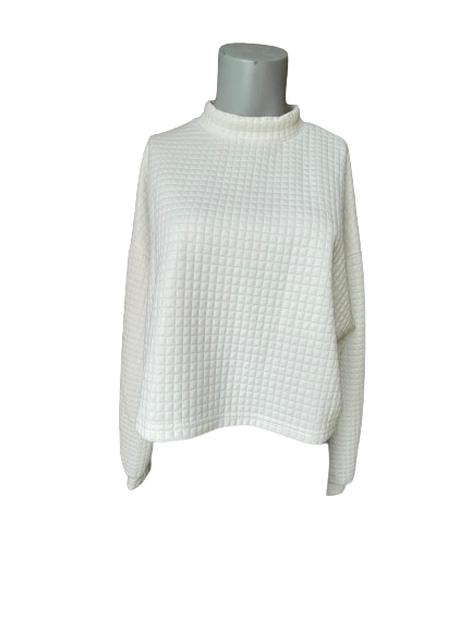 White quilted cropped pullover on a mannequin against a gray background.