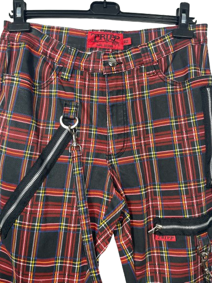 Red and black plaid cargo pants with silver zippers and a black shoulder strap, hanging on a black hanger against a white background.