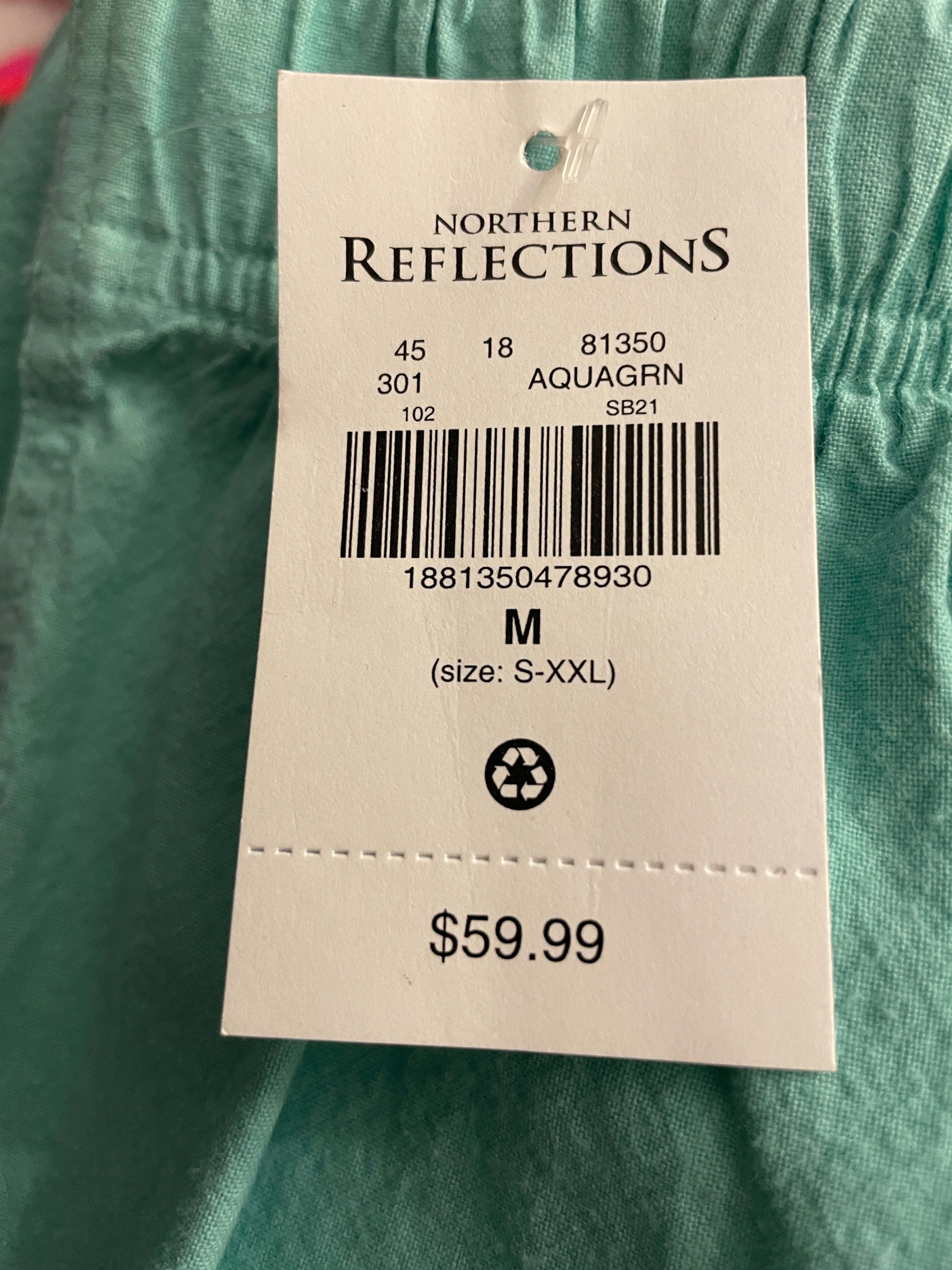 A white Northern Reflections clothing tag attached to a teal-green garment, showing the brand name, barcode, size M, and price $59.99.