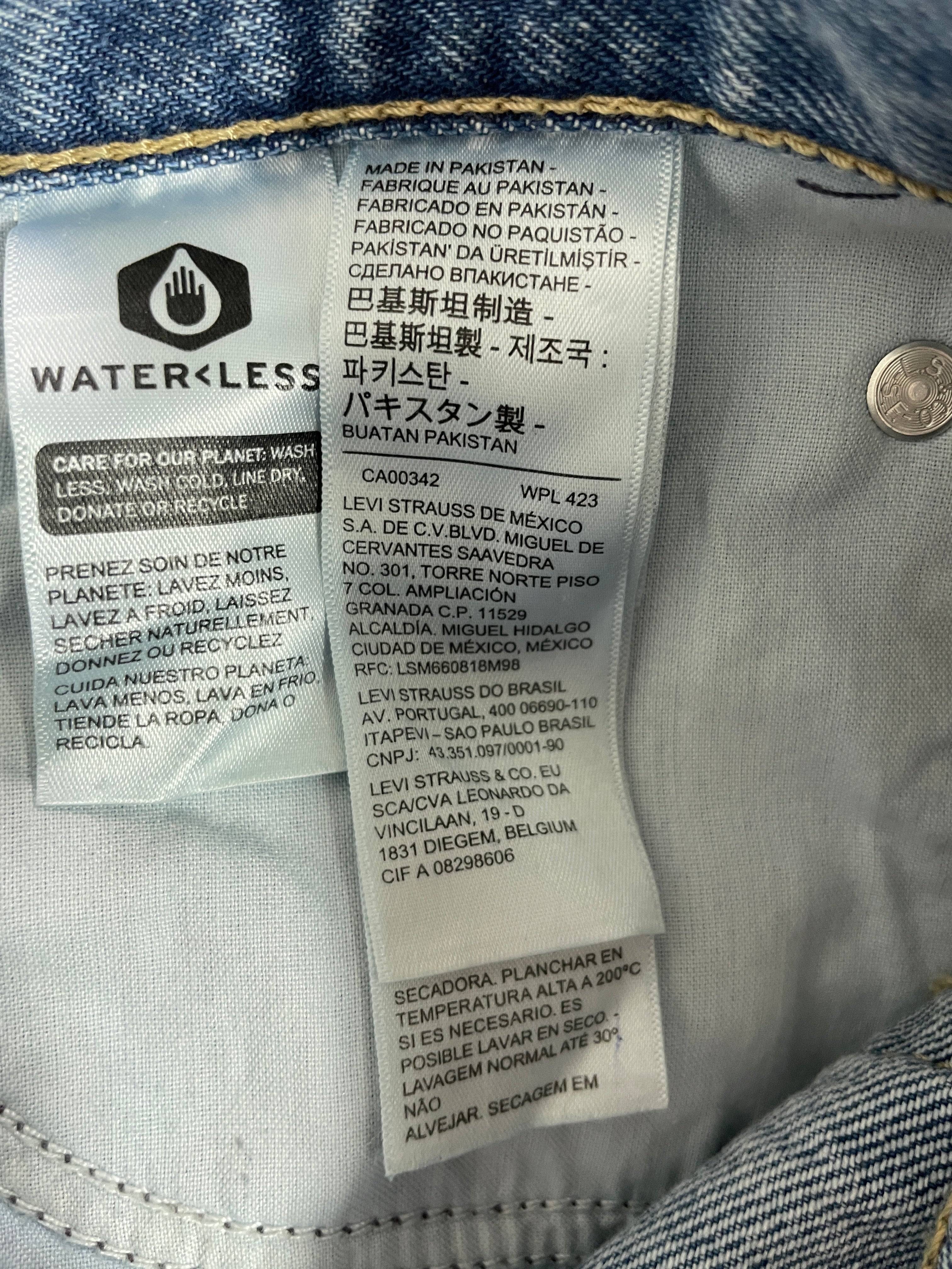 Close-up of a denim garment showing the interior care label and sewn-in size/brand label. The visible text includes Waterless and Levi's branding, along with care instructions and manufacturing details.