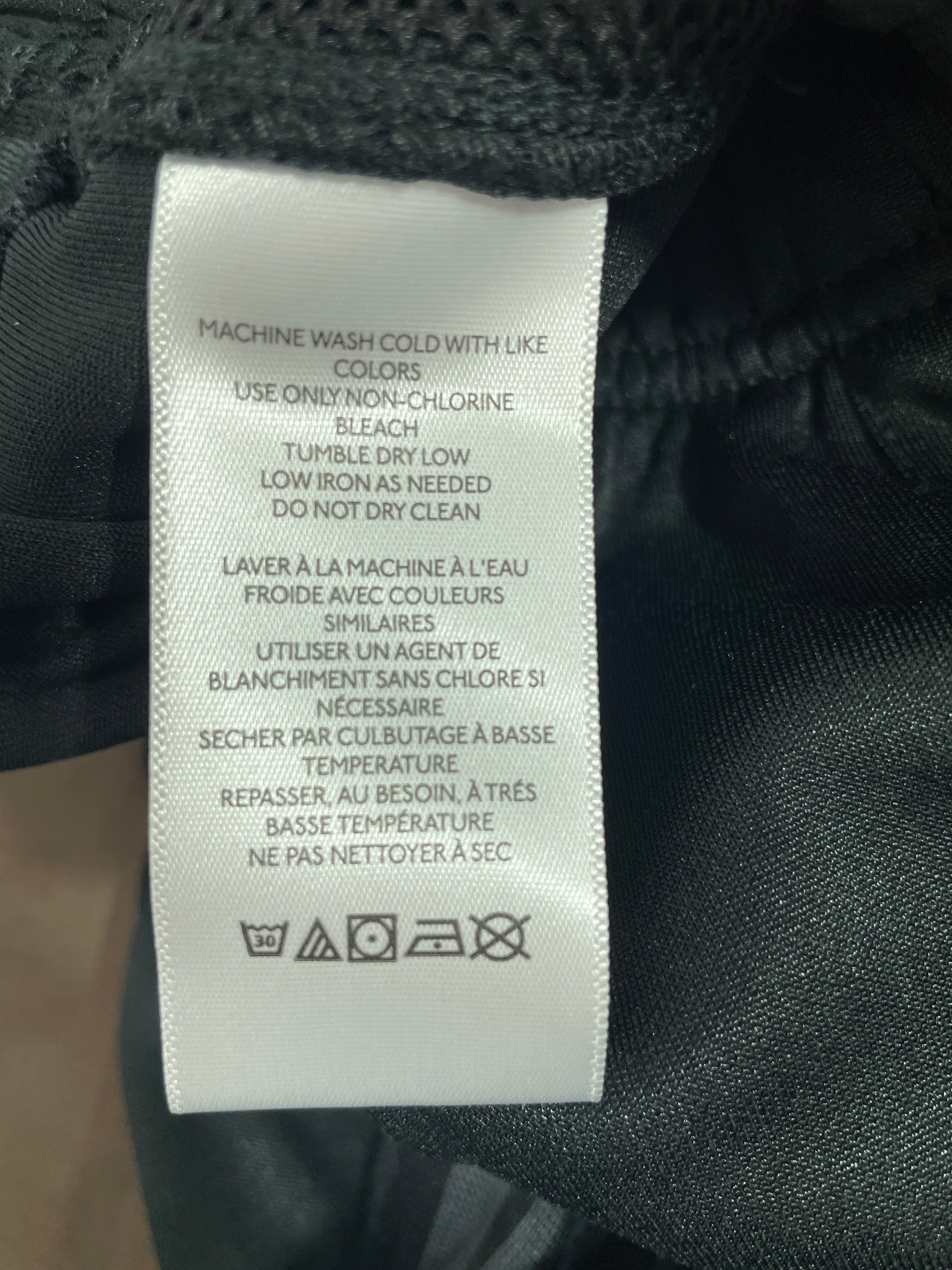 Urban Outfitters polyester track pants care label with washing instructions