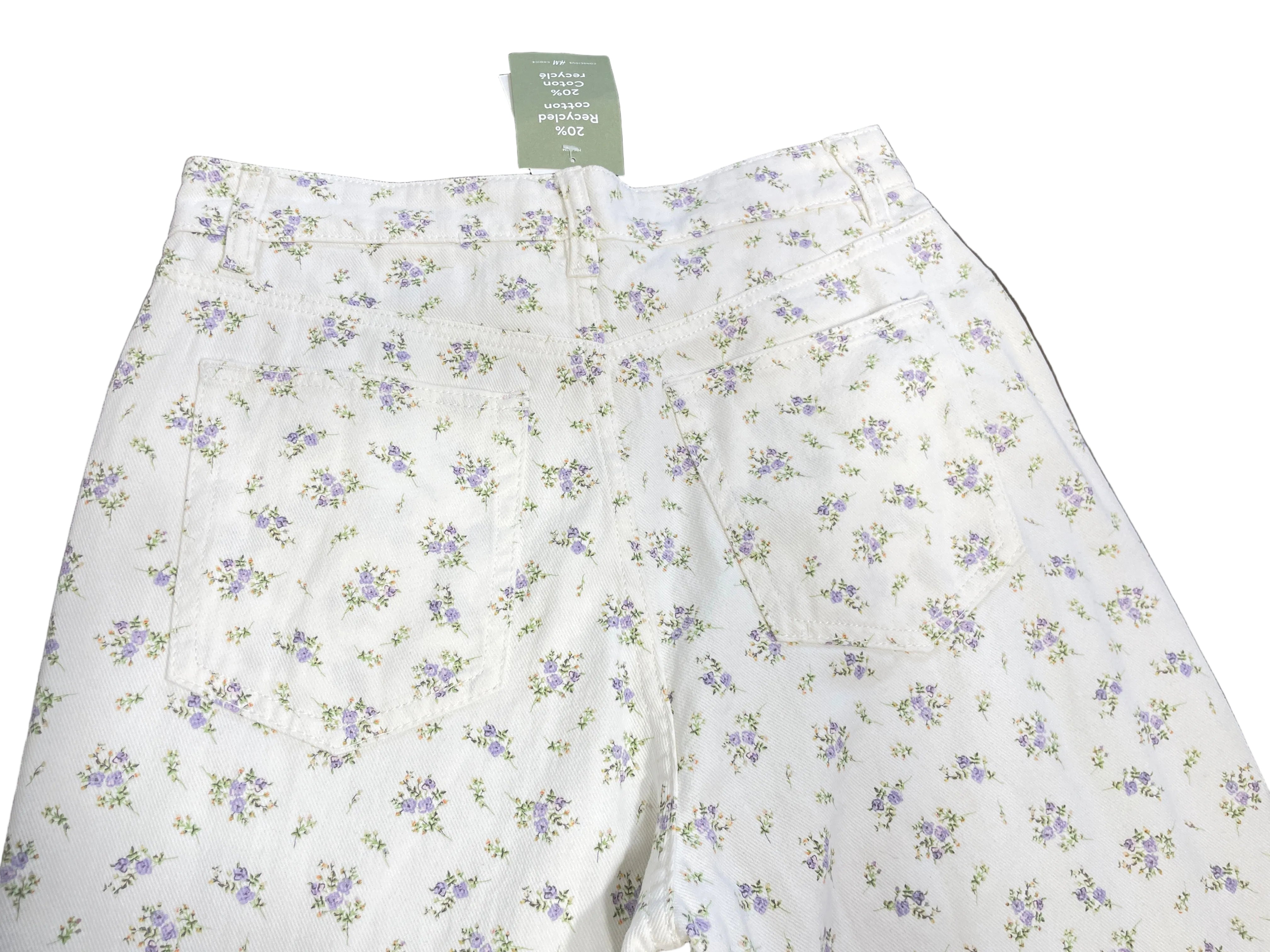 1. Back view of H&M white floral print jeans showing two patch pockets and delicate purple flowers