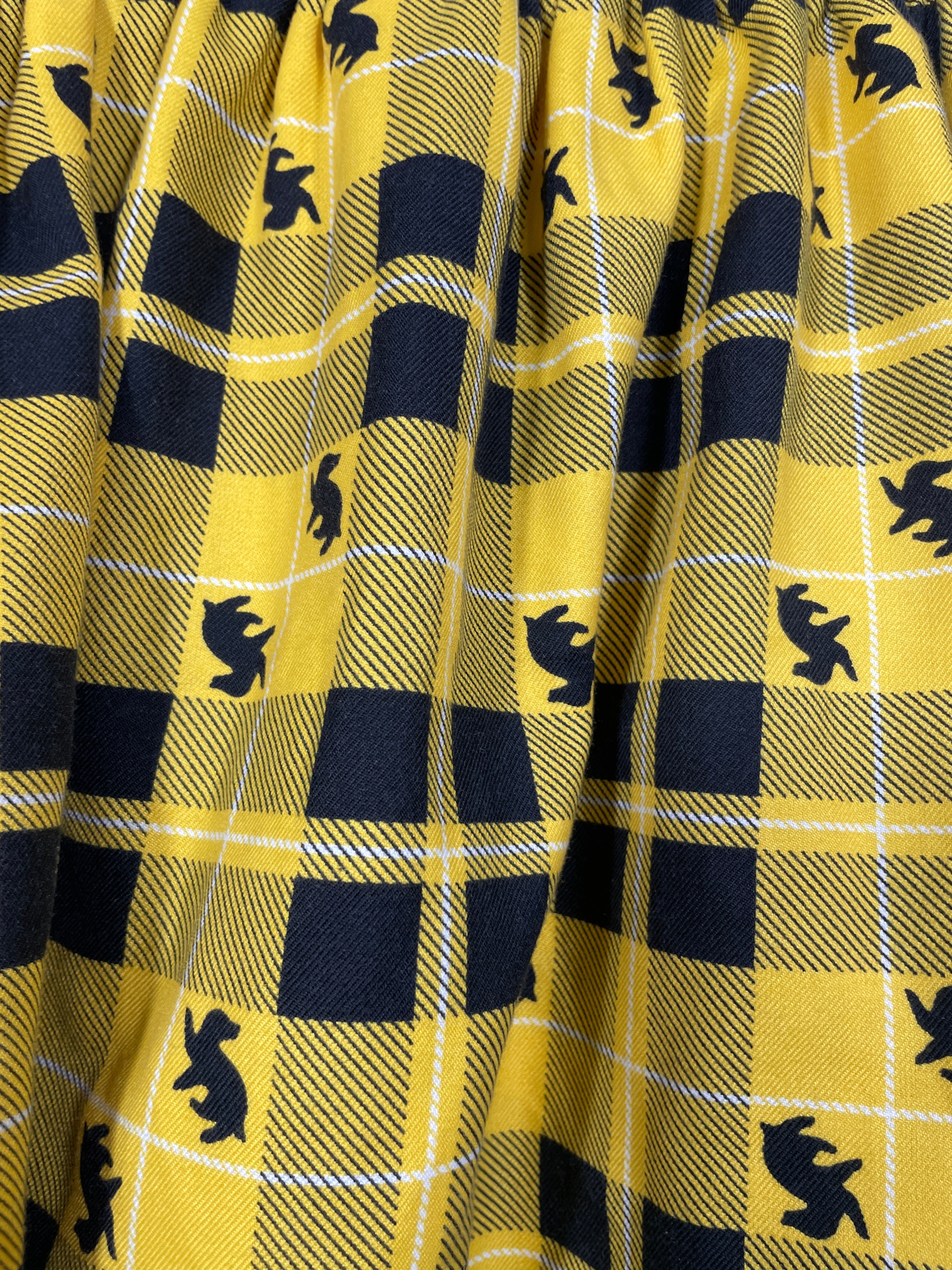 Harry Potter Hufflepuff skirt yellow black plaid fabric with badger silhouettes close up