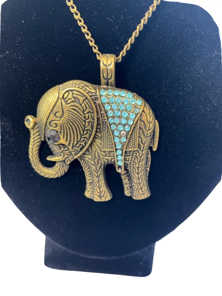 Gold elephant pendant with turquoise stones on a black stand