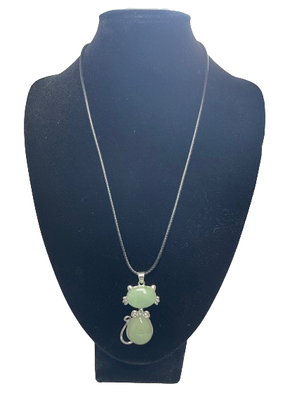 Necklace with a green cat pendant on a black mannequin bust 