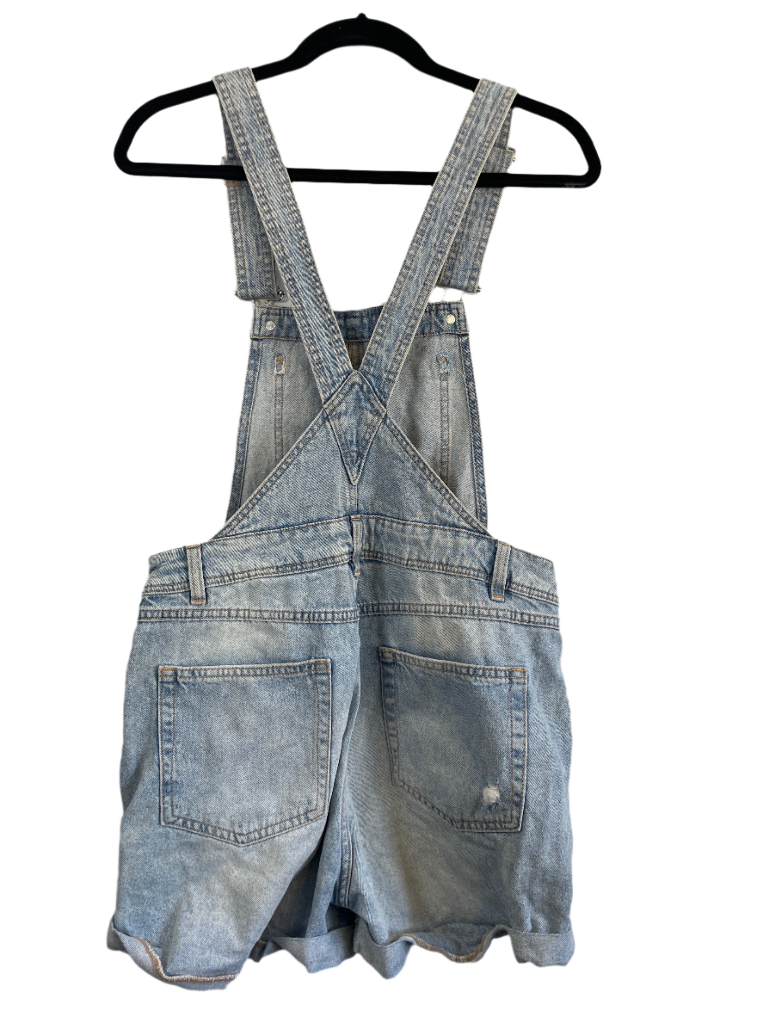 Blue denim jeans on a hanger against a light background