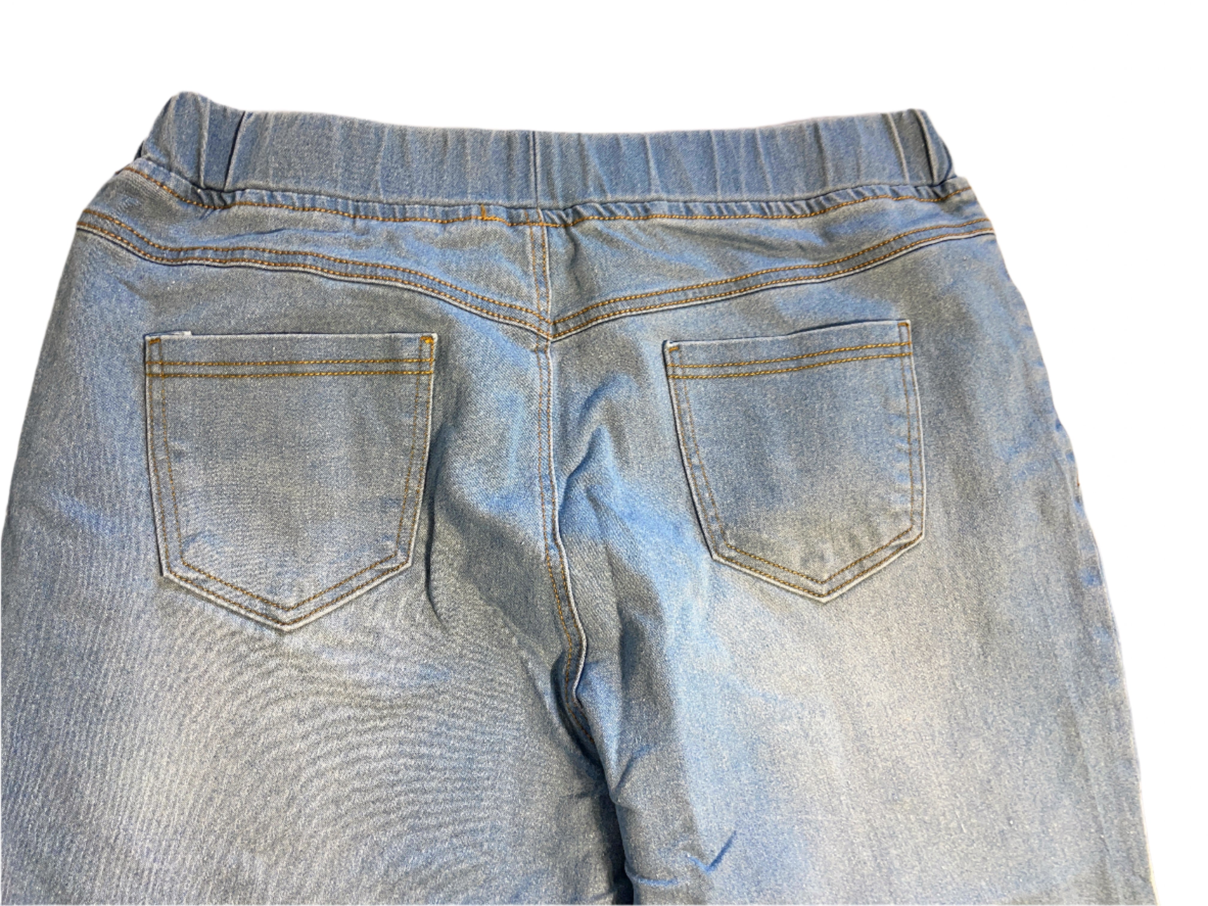 Back view of a pair of blue jeans on a light-colored surface.