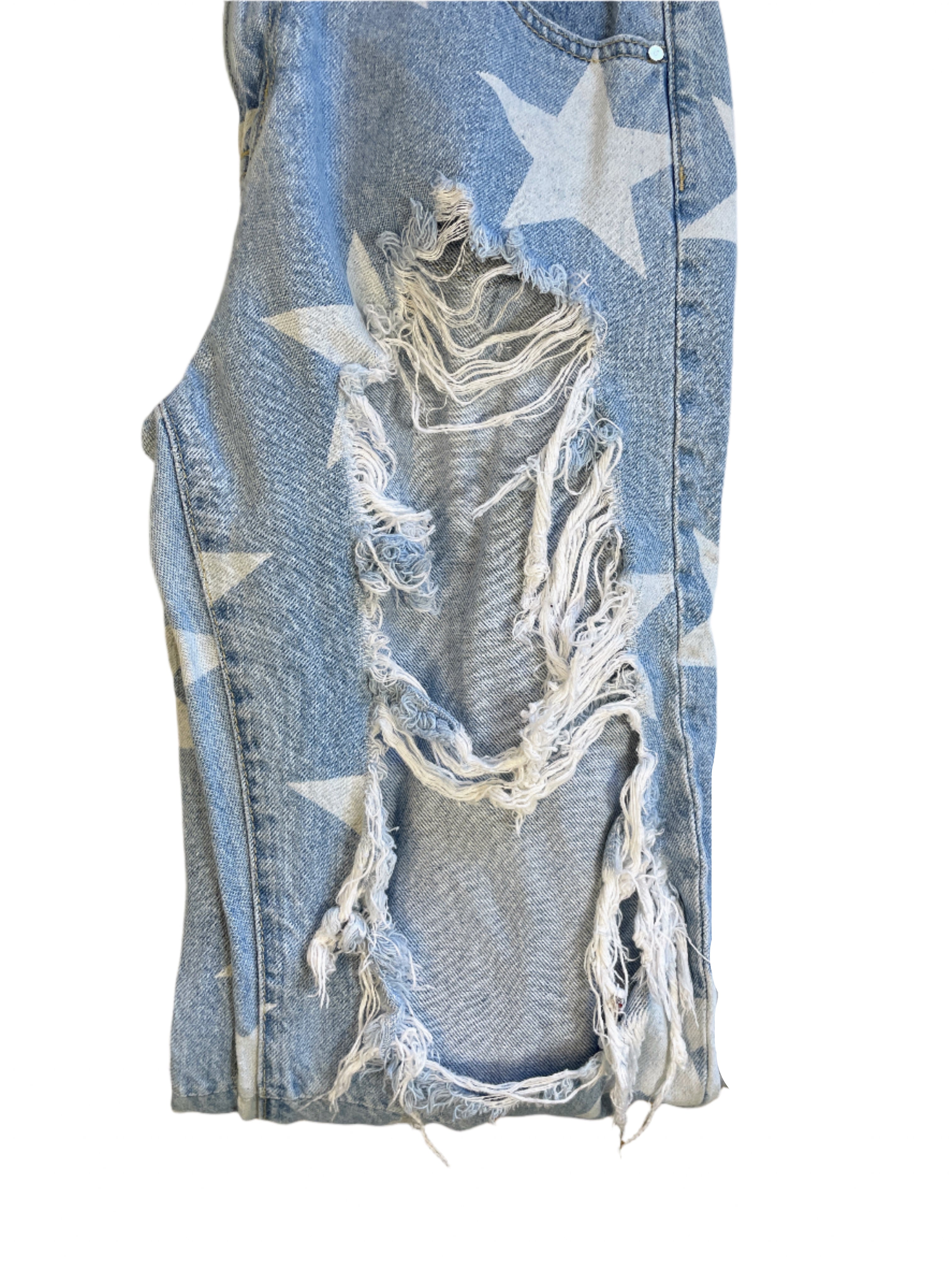 Distressed denim jeans with star patterns on a white surface