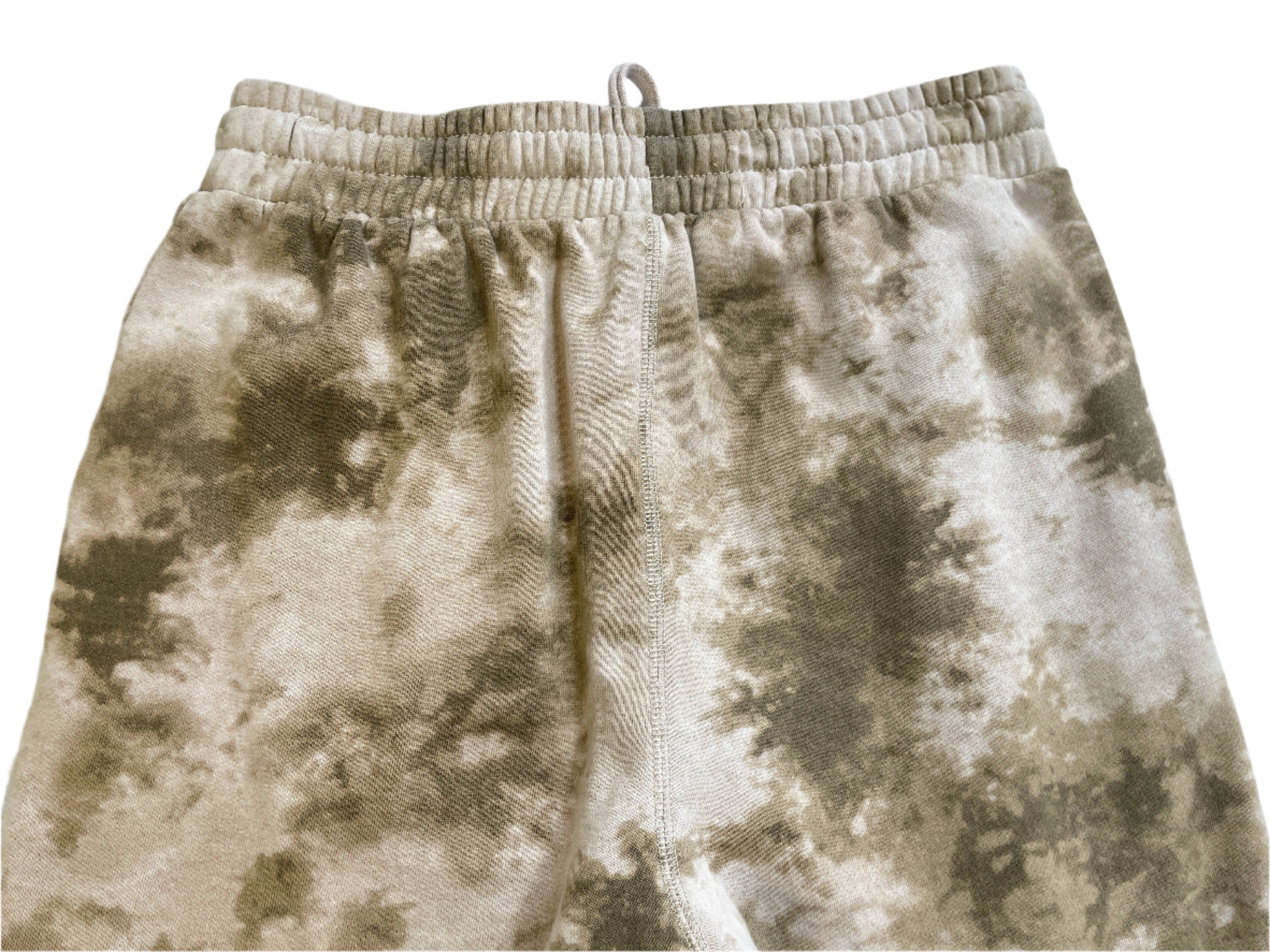 Beige tie-dye shorts on a white surface