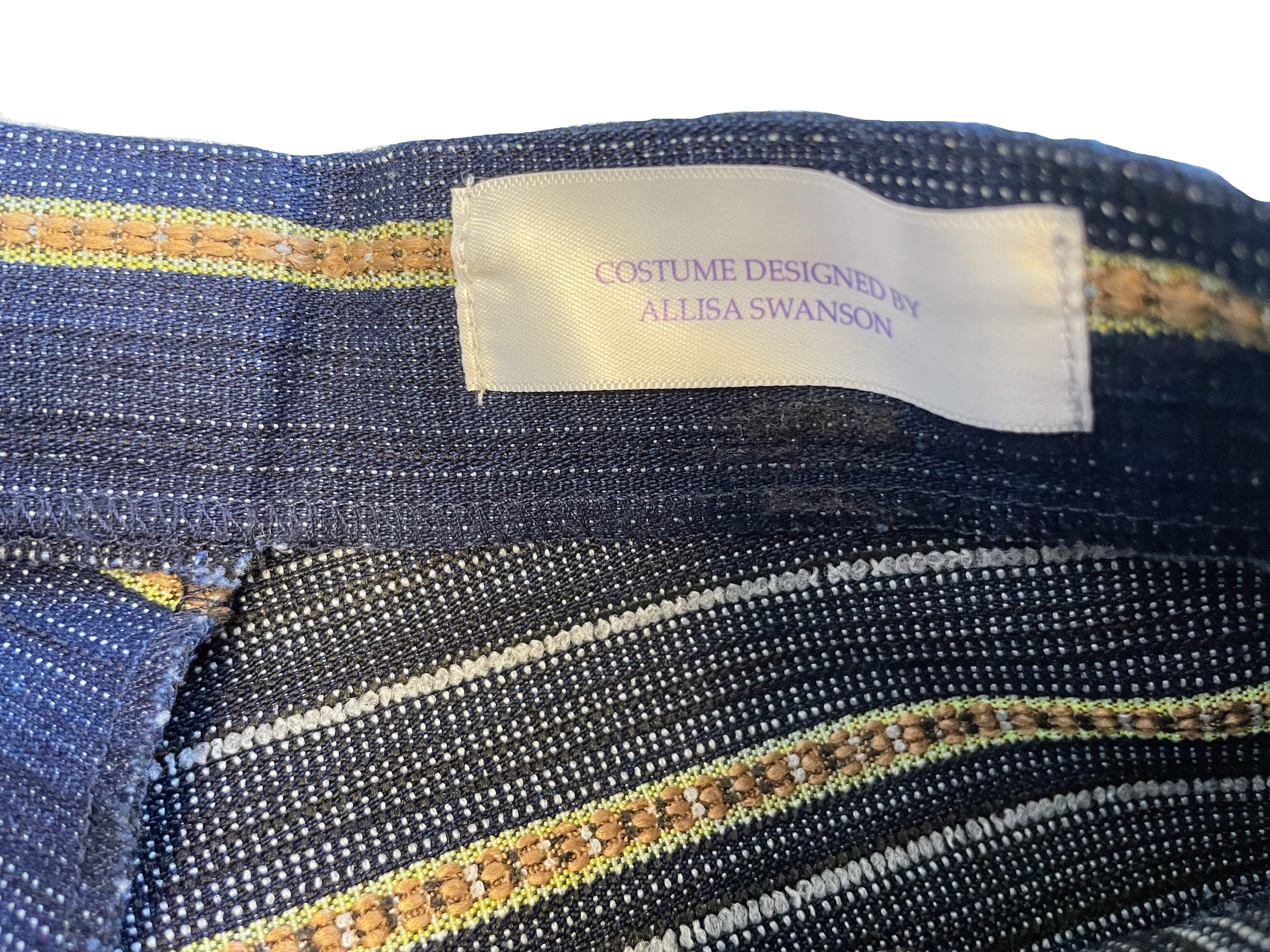 Textile with a label indicating 'Costume Designed by Allisa Swanson'