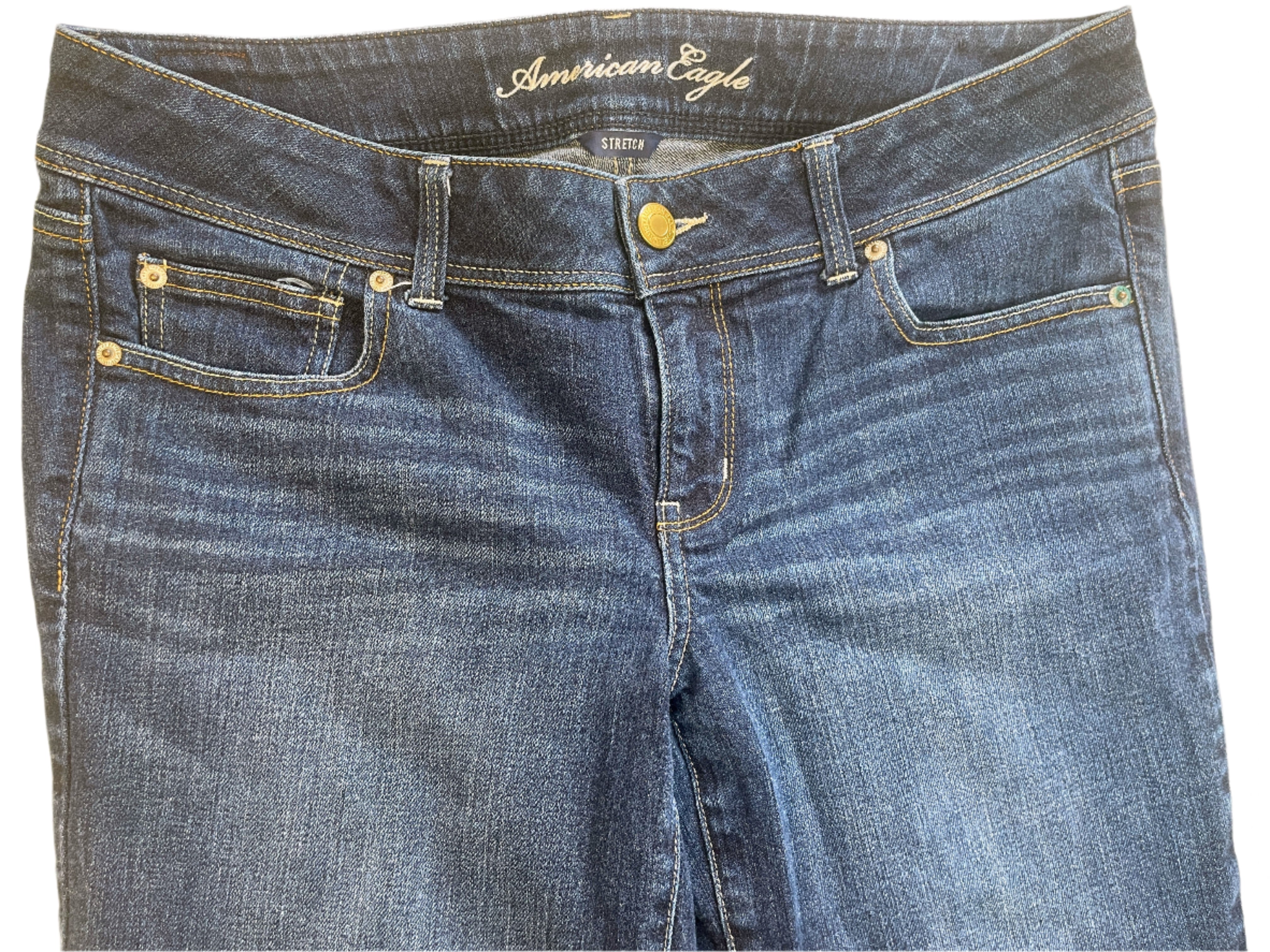 Folded pair of blue jeans with 'American Eagle' branding on a beige background
