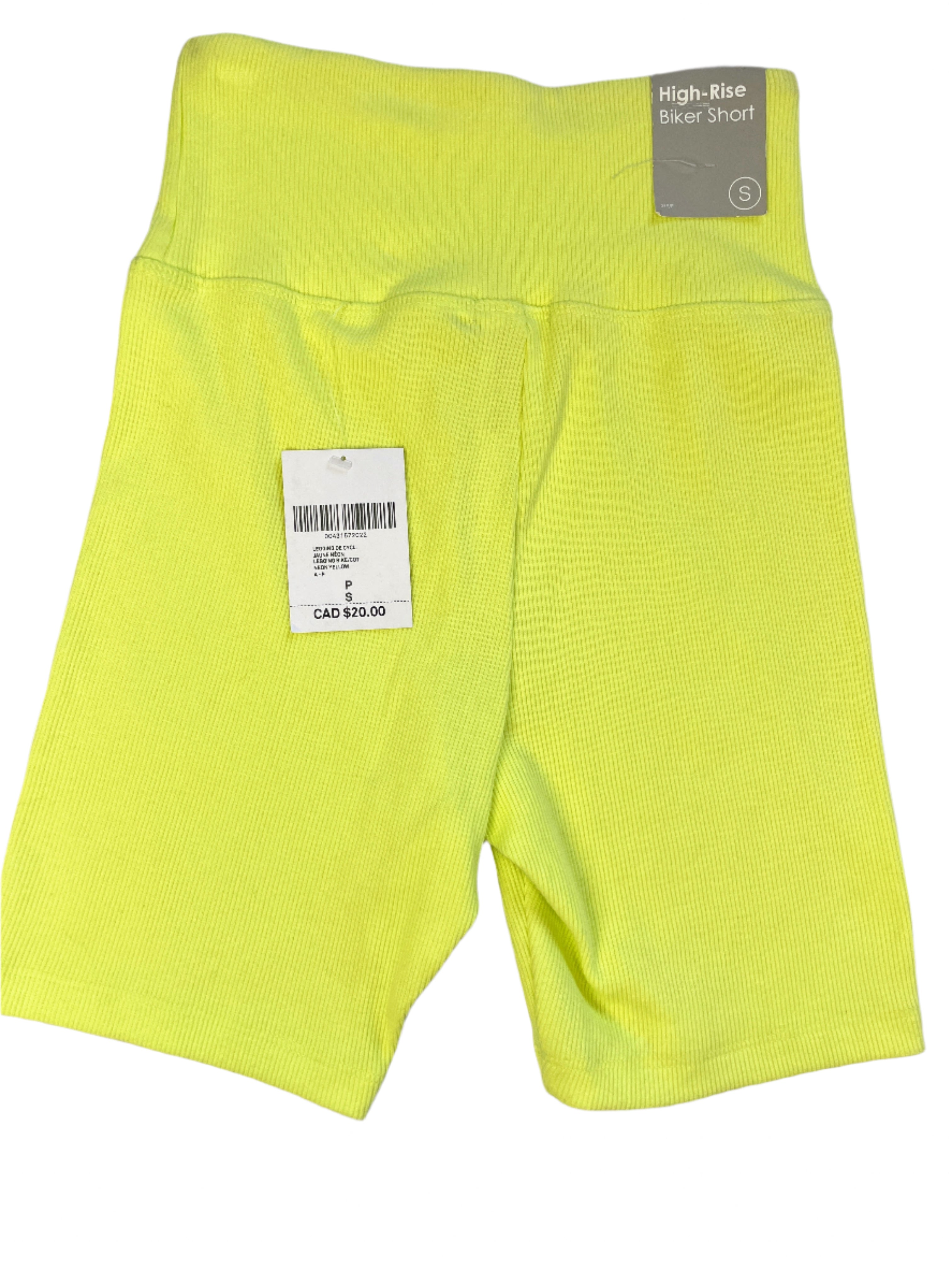 Yellow high-rise biker shorts with a tag on a gray surface