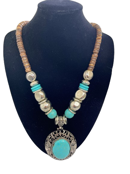 Necklace with turquoise pendant and wooden beads on a black mannequin