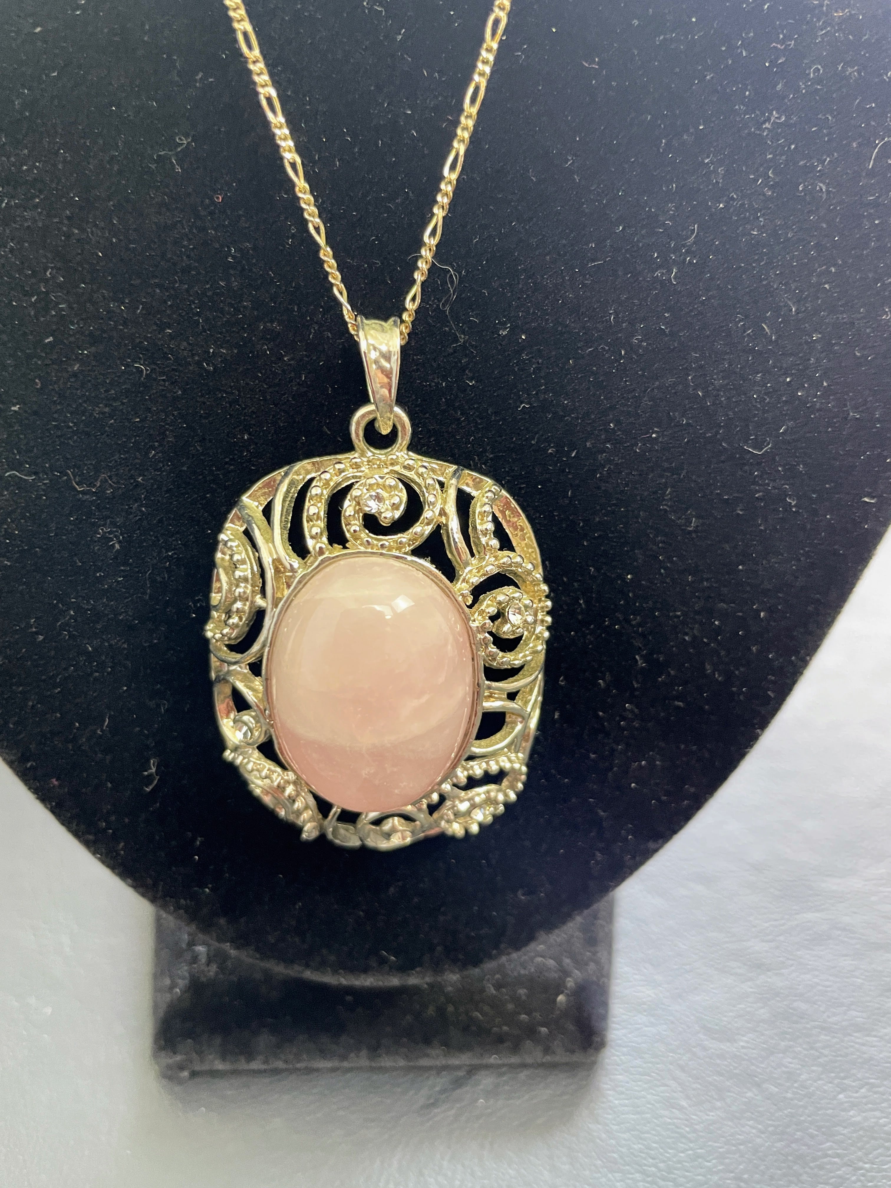 Necklace with a pink pendant on a black stand