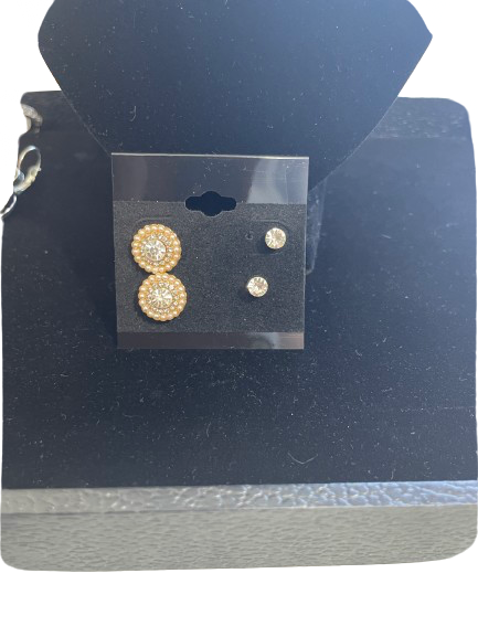 Pair of gold earrings on a clear card with a black background
