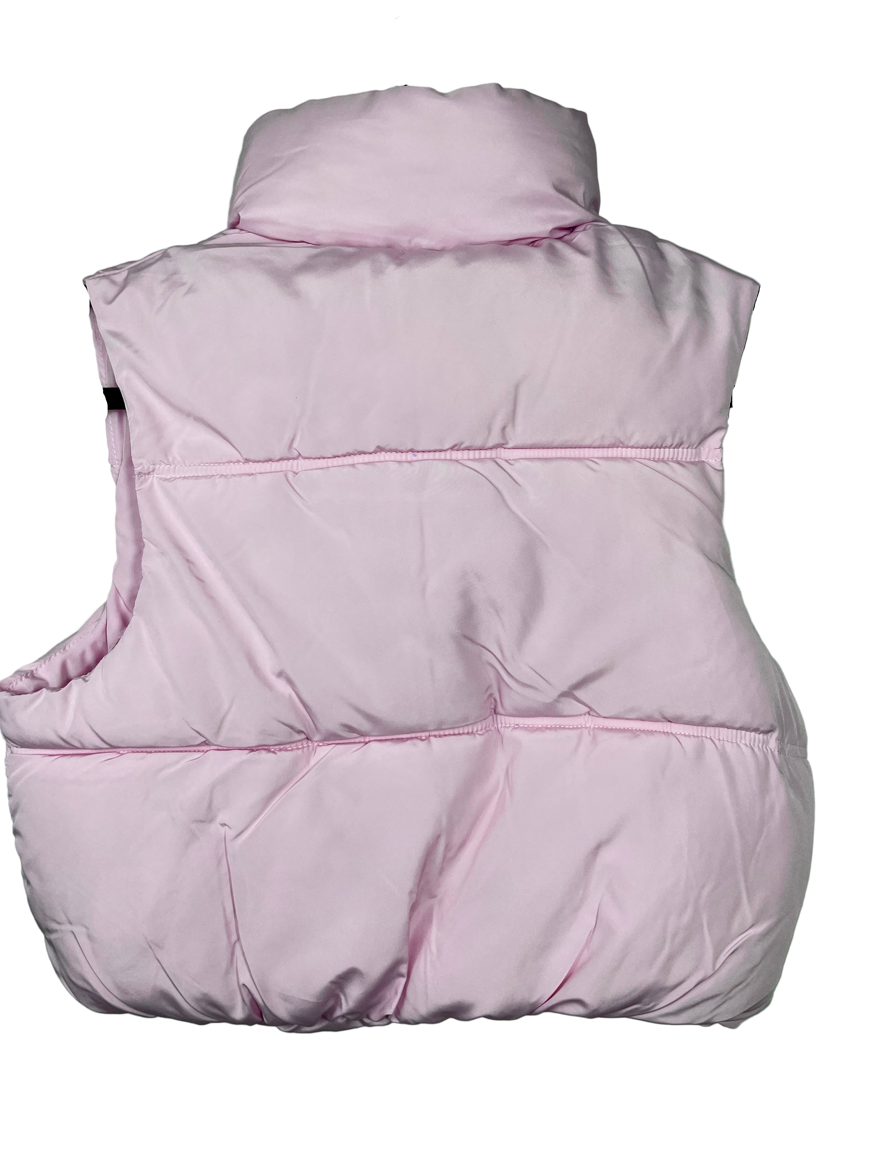 Pink puffer vest on a hanger against a light green wall