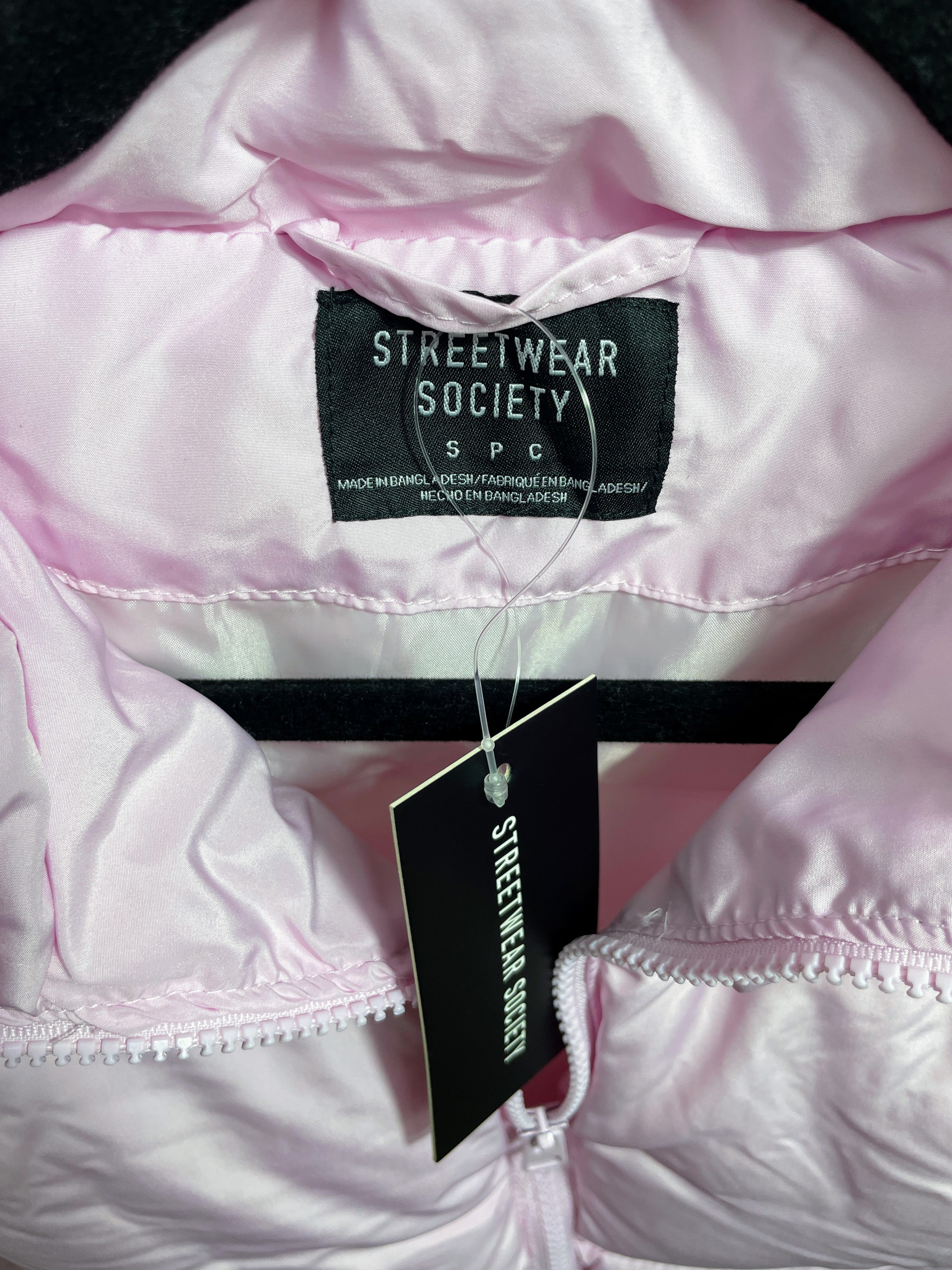 Pink jacket with 'Streetwear Society' tag on a dark background