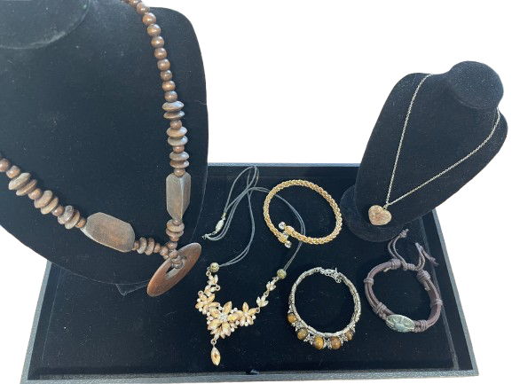 Collection of jewelry on black display stands with a white background